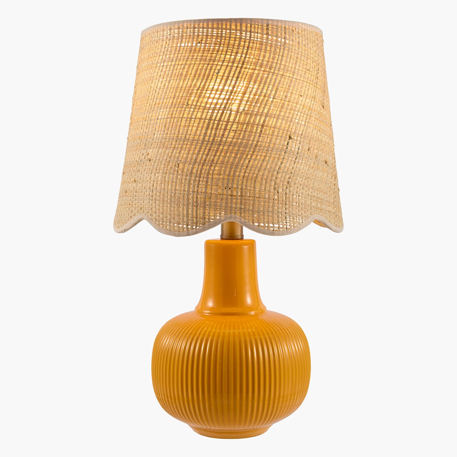 Table lamp with ribbed orange base and wicker shade on a white background