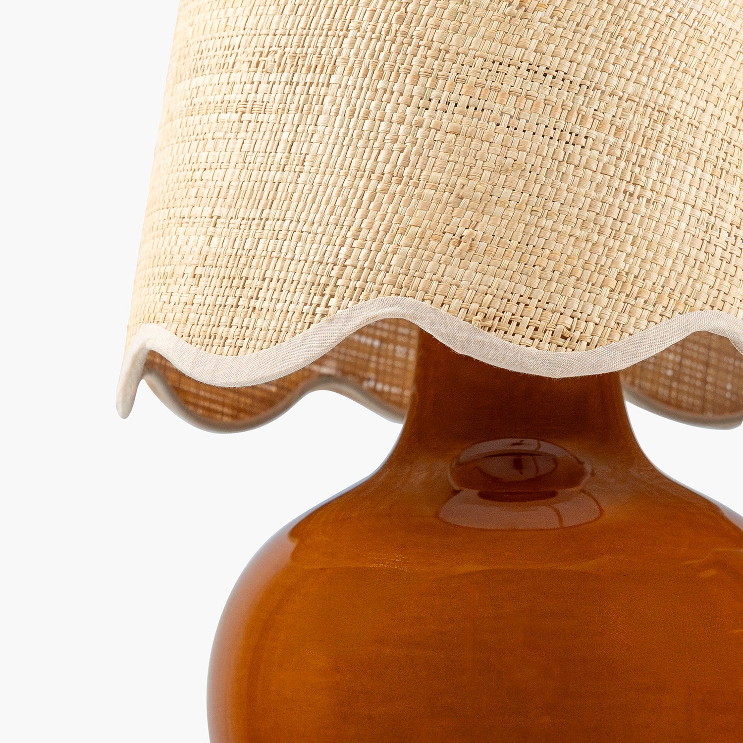 Close-up of a lamp with a textured beige shade and brown base on a white background