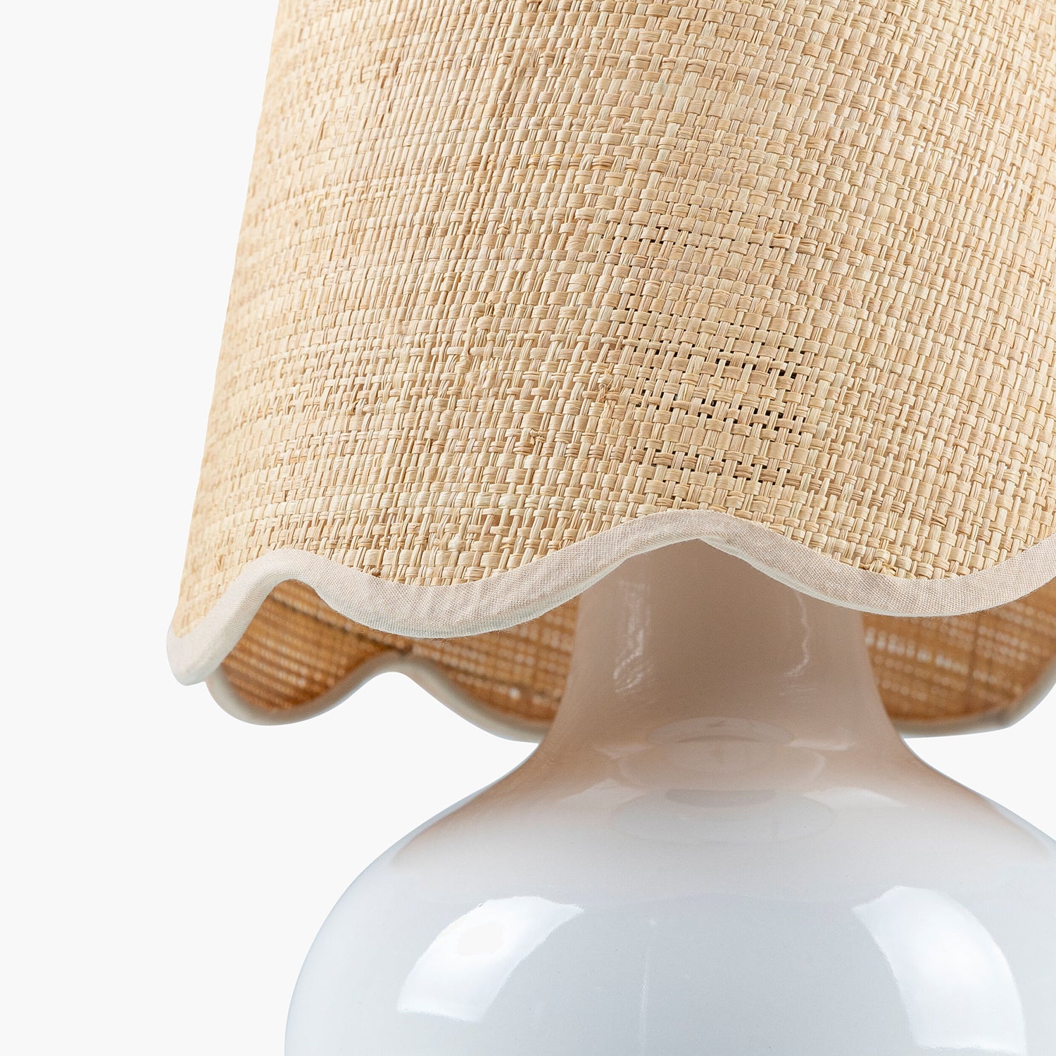 Close-up of a lamp with a beige woven shade on a white background