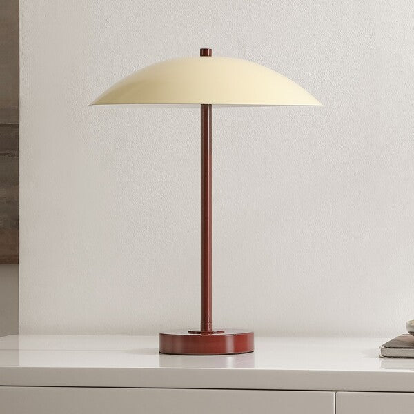 Table lamp with beige shade and red base on a white surface.