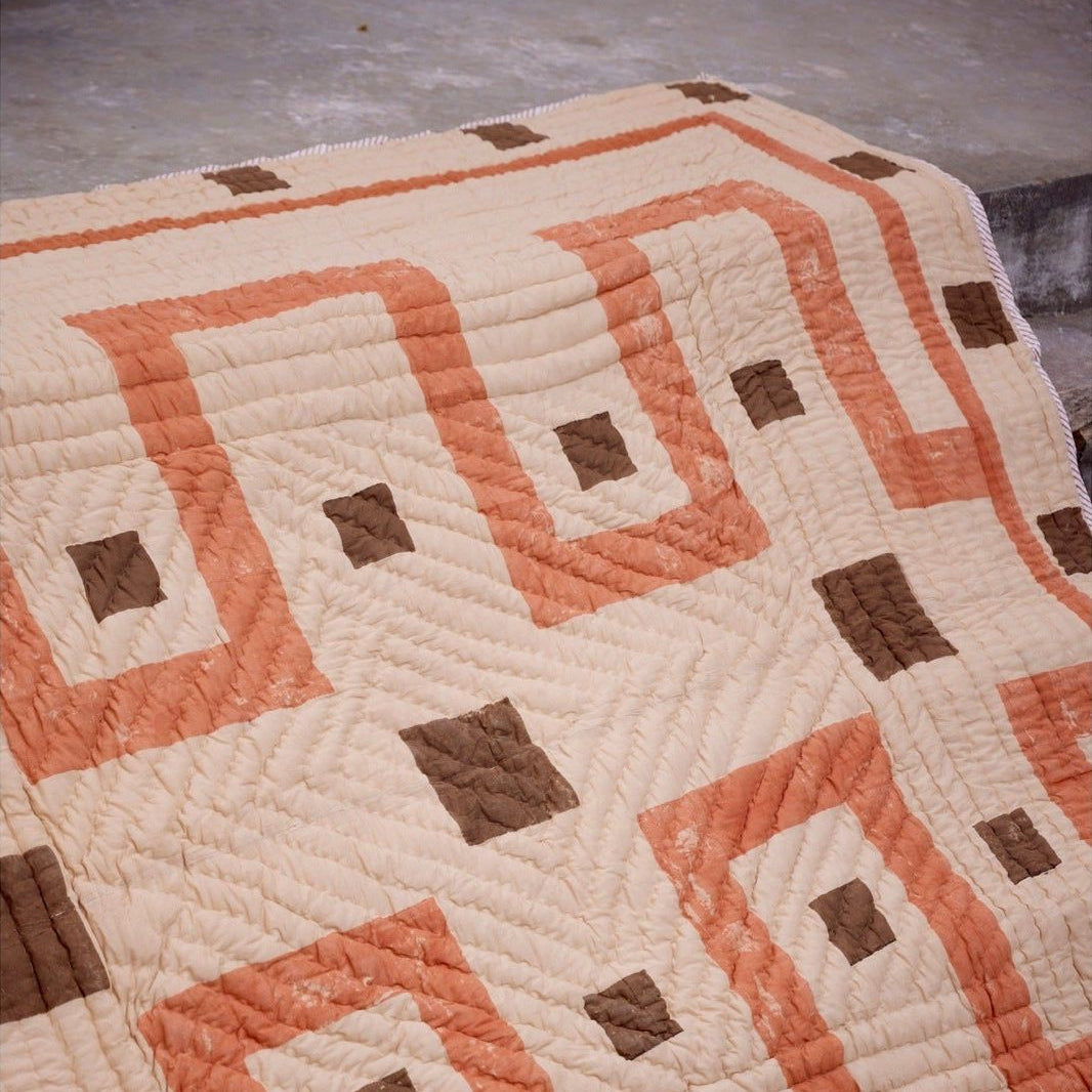 Quilt with geometric pattern on a plain background