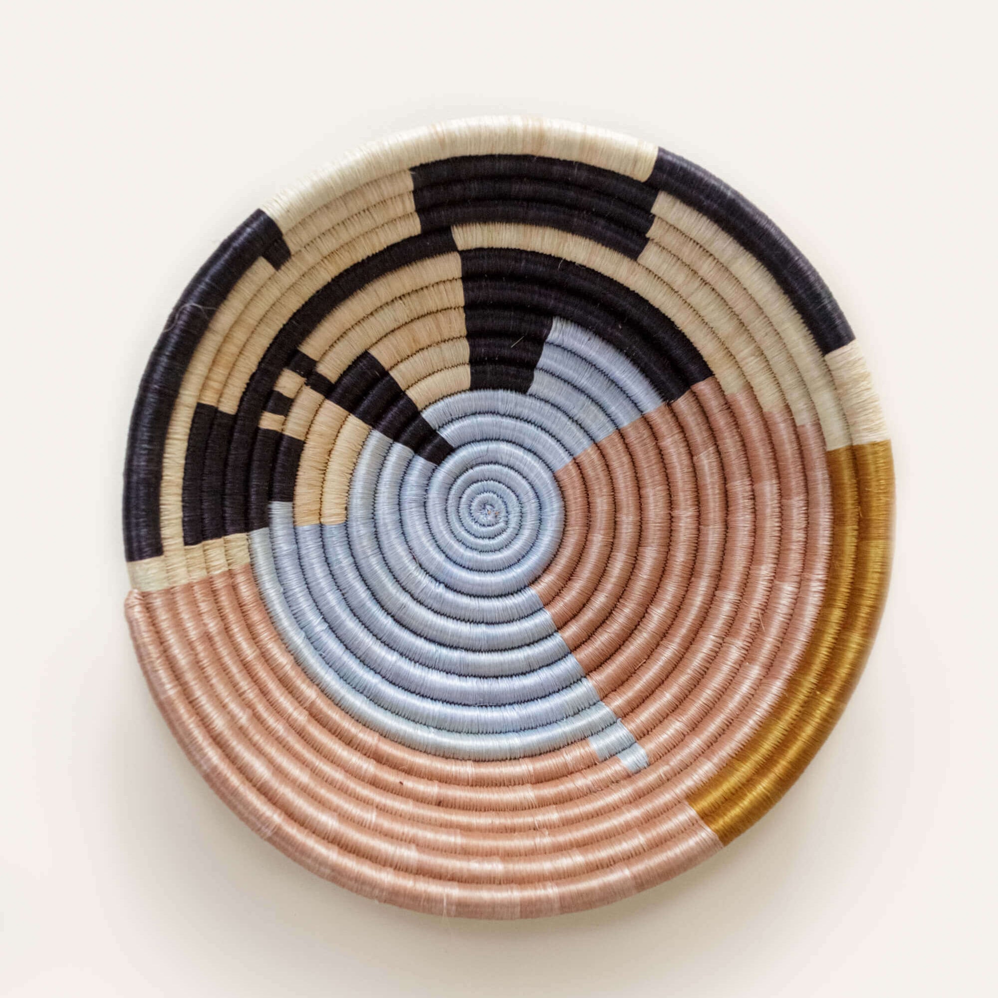 Multi-colored woven basket with concentric circle pattern on a white background