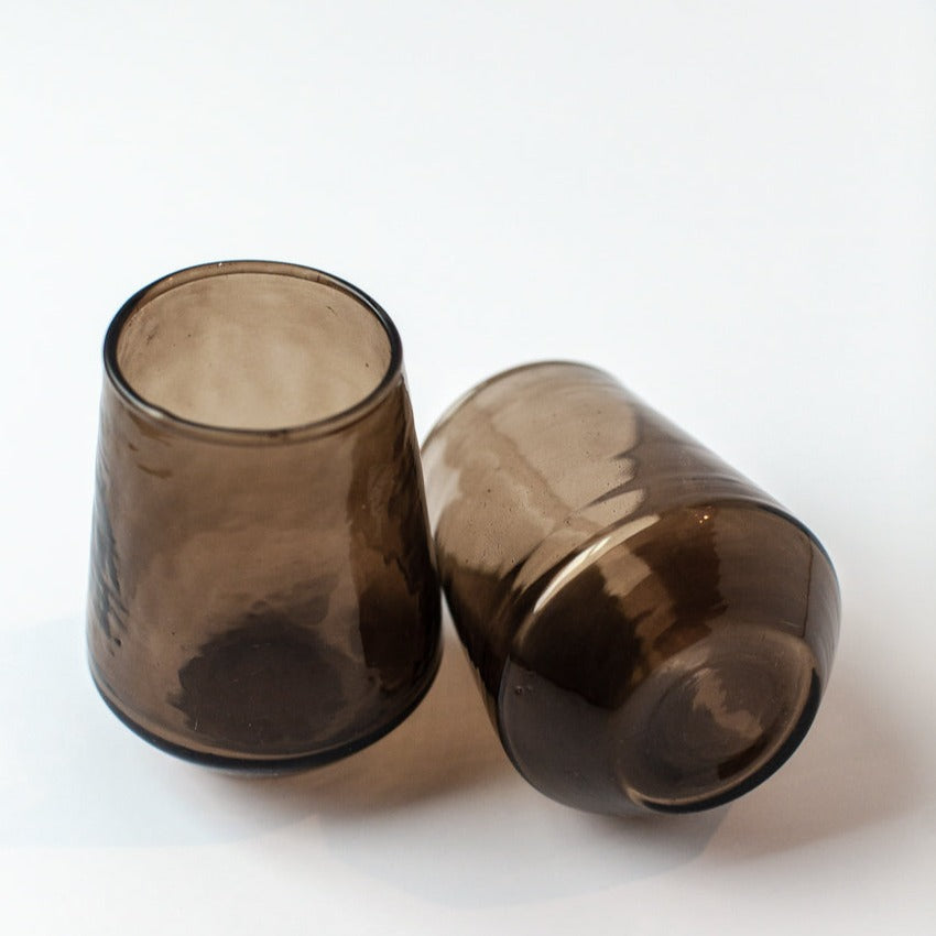 Two brown glass tumblers on a white background