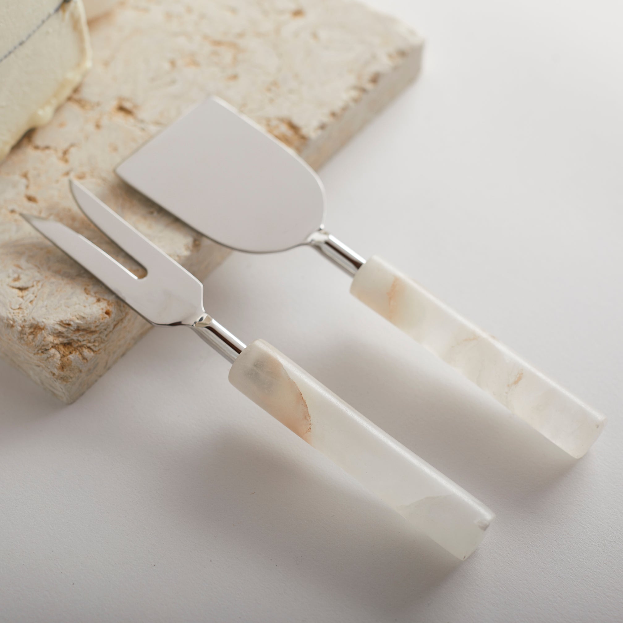 Set of marble-handled cake server and knife on a light background
