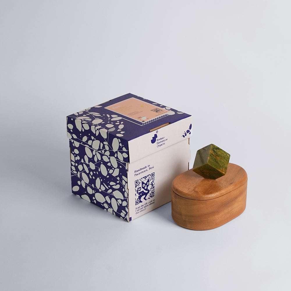 Wooden box with a geometric lid and patterned packaging on a light gray background