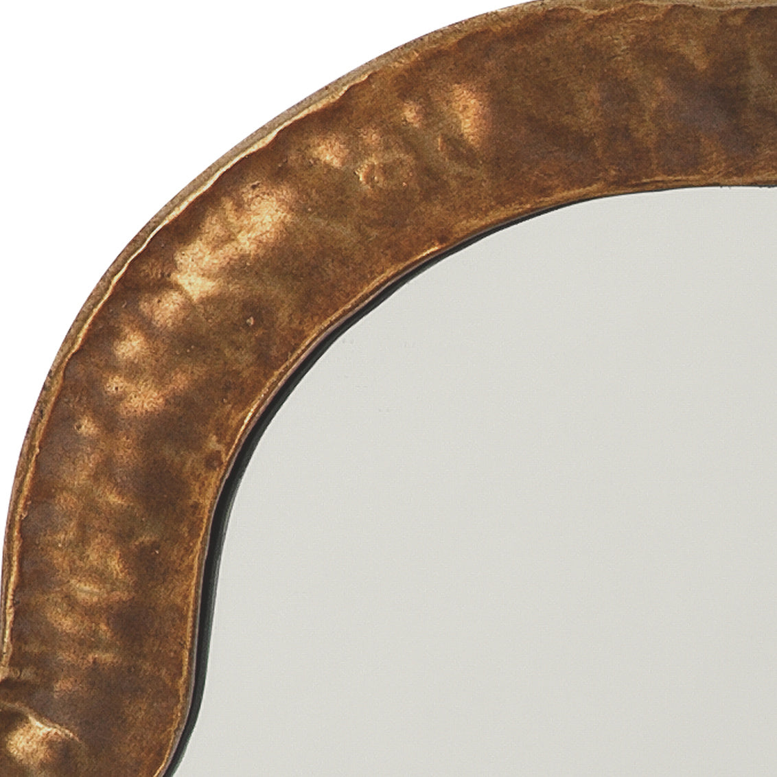 Round mirror with a textured brass frame on a light gray background