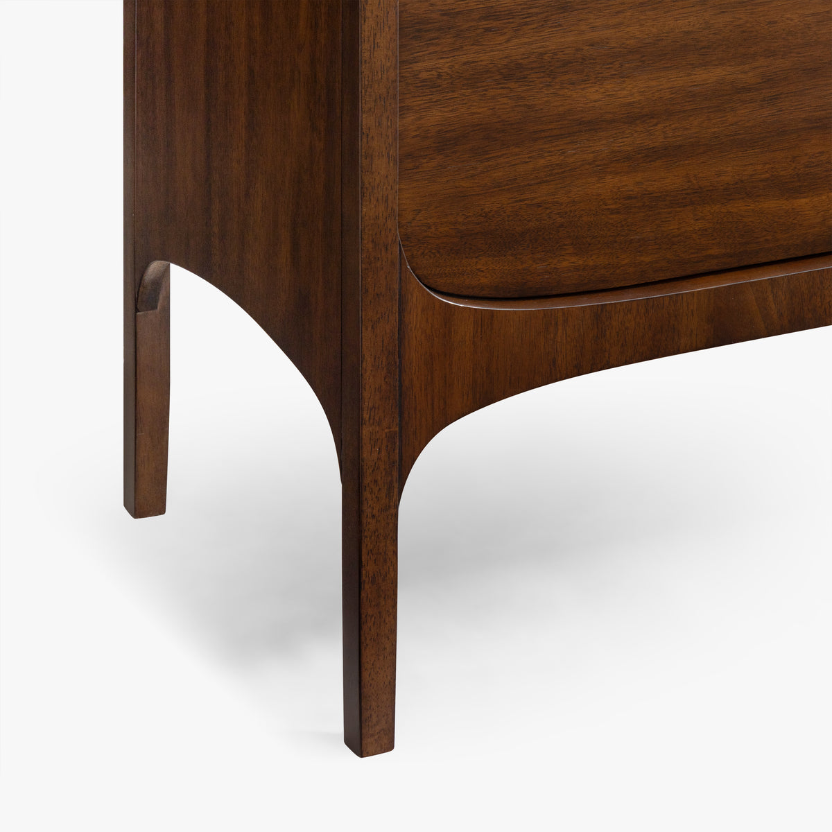 Close-up of a mid-century modern wooden nightstand or dresser leg and drawer front, showing rich dark walnut wood grain against a clean white background.