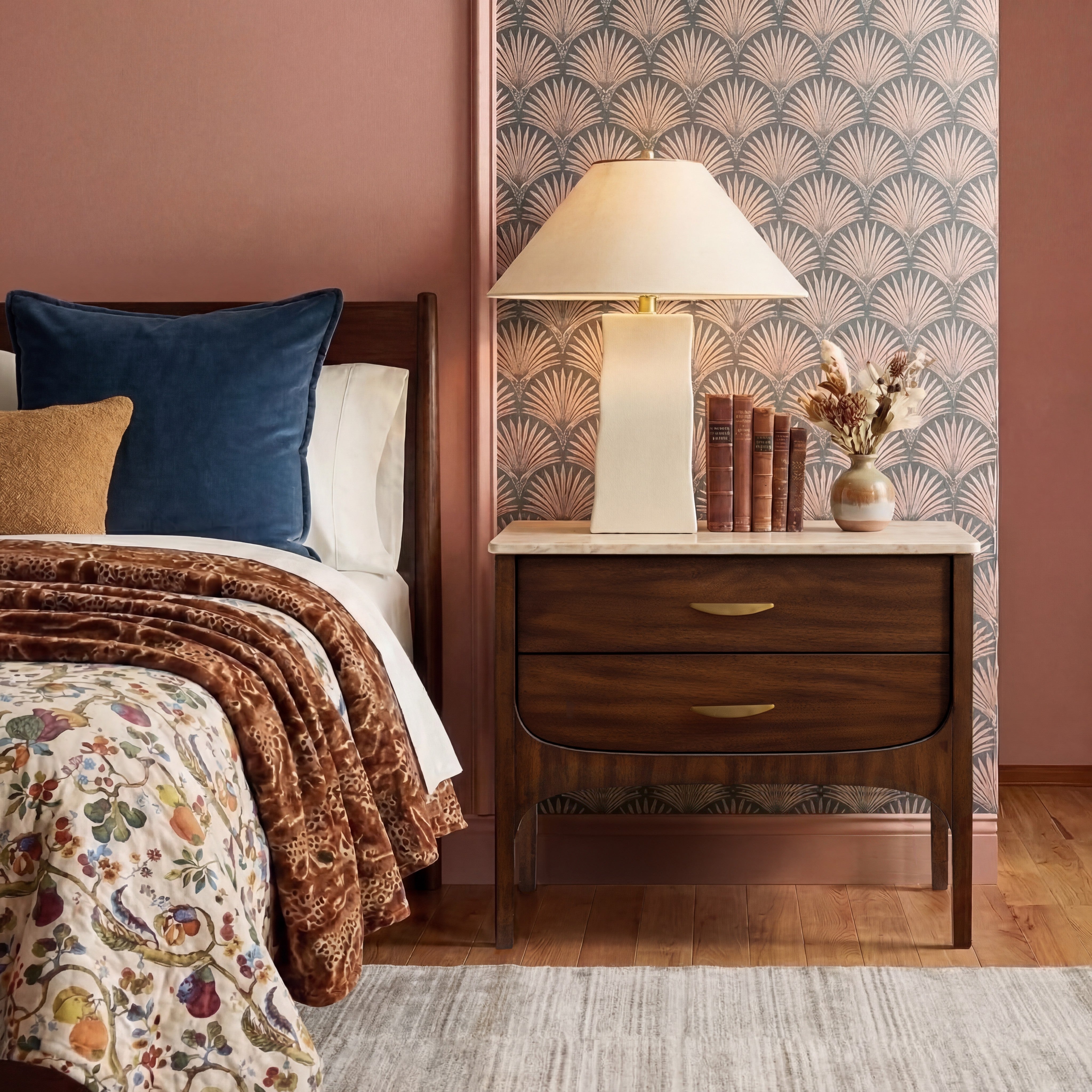 Bedroom with floral bedspread, wooden nightstand, and decorative lamp.