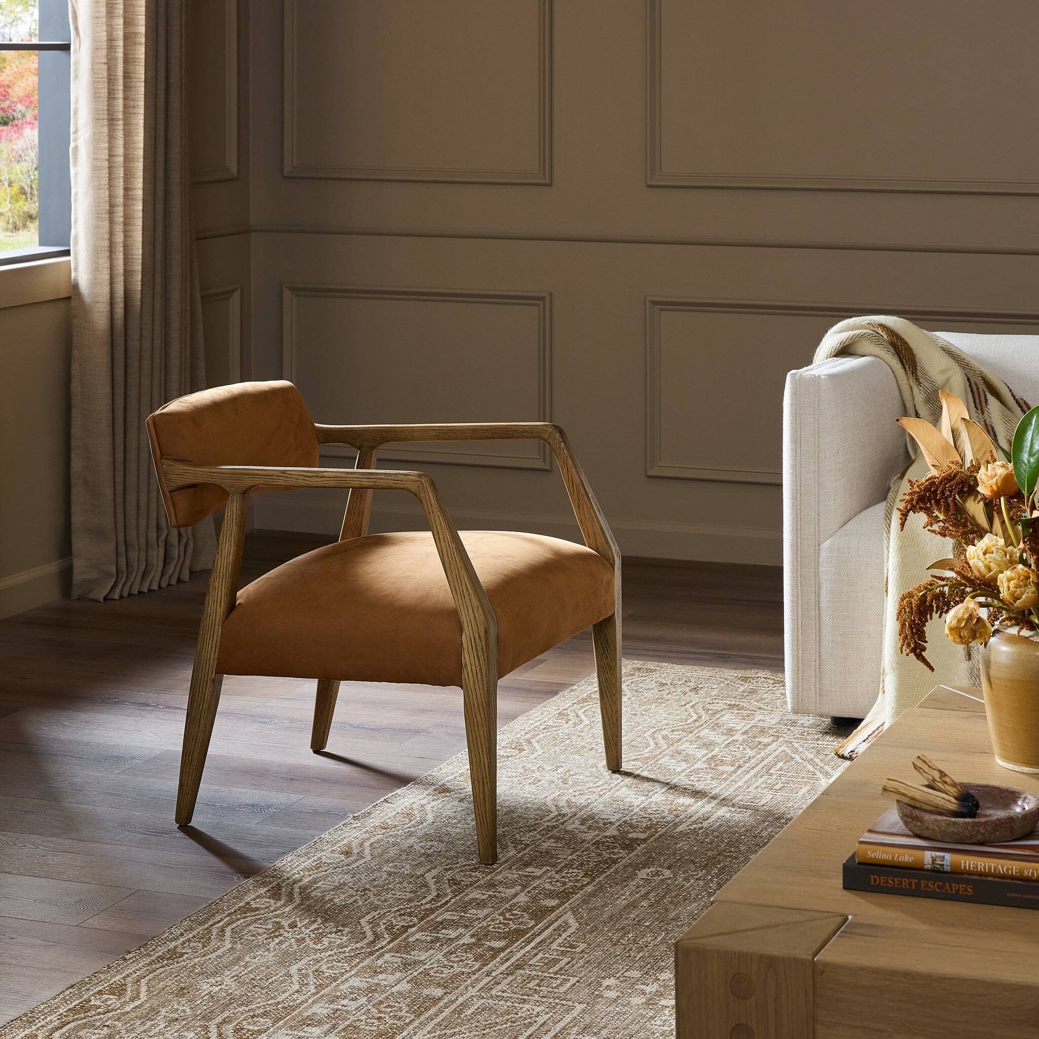 Brown armchair in a living room with a sofa and decorative items.