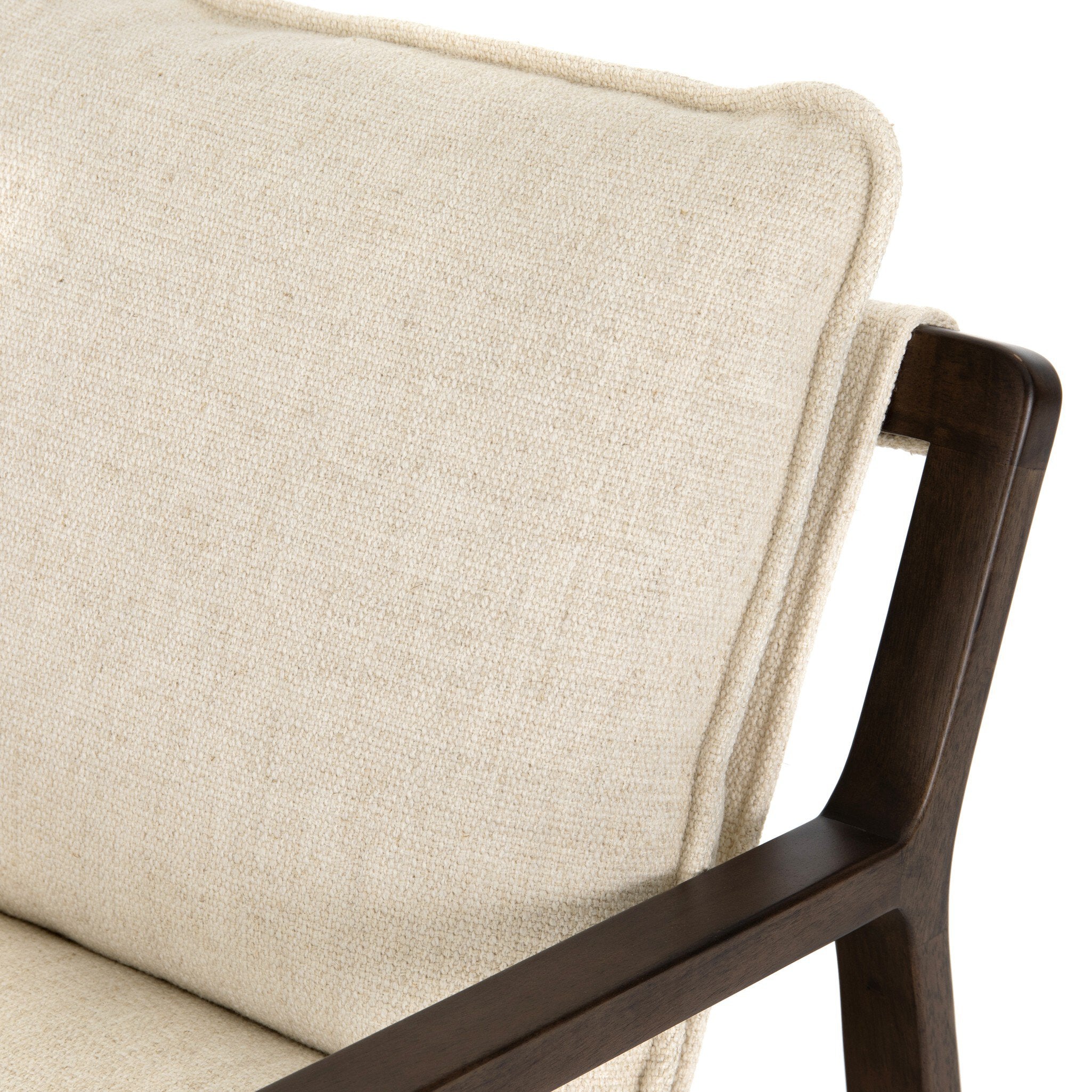 Close-up of a beige upholstered chair with dark wooden armrests on a white background