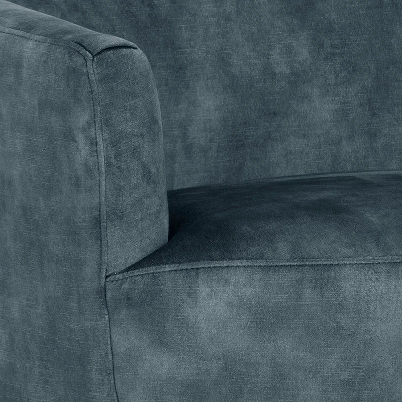 Close-up of a dark slate blue textured fabric armchair, showing the armrest, seat cushion, and upholstery material.