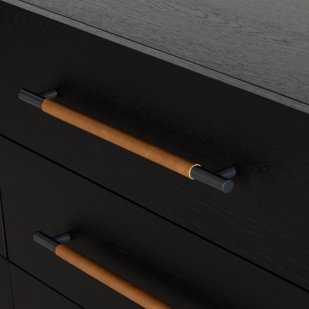 Dark wooden dresser with tan leather wrapped iron handles