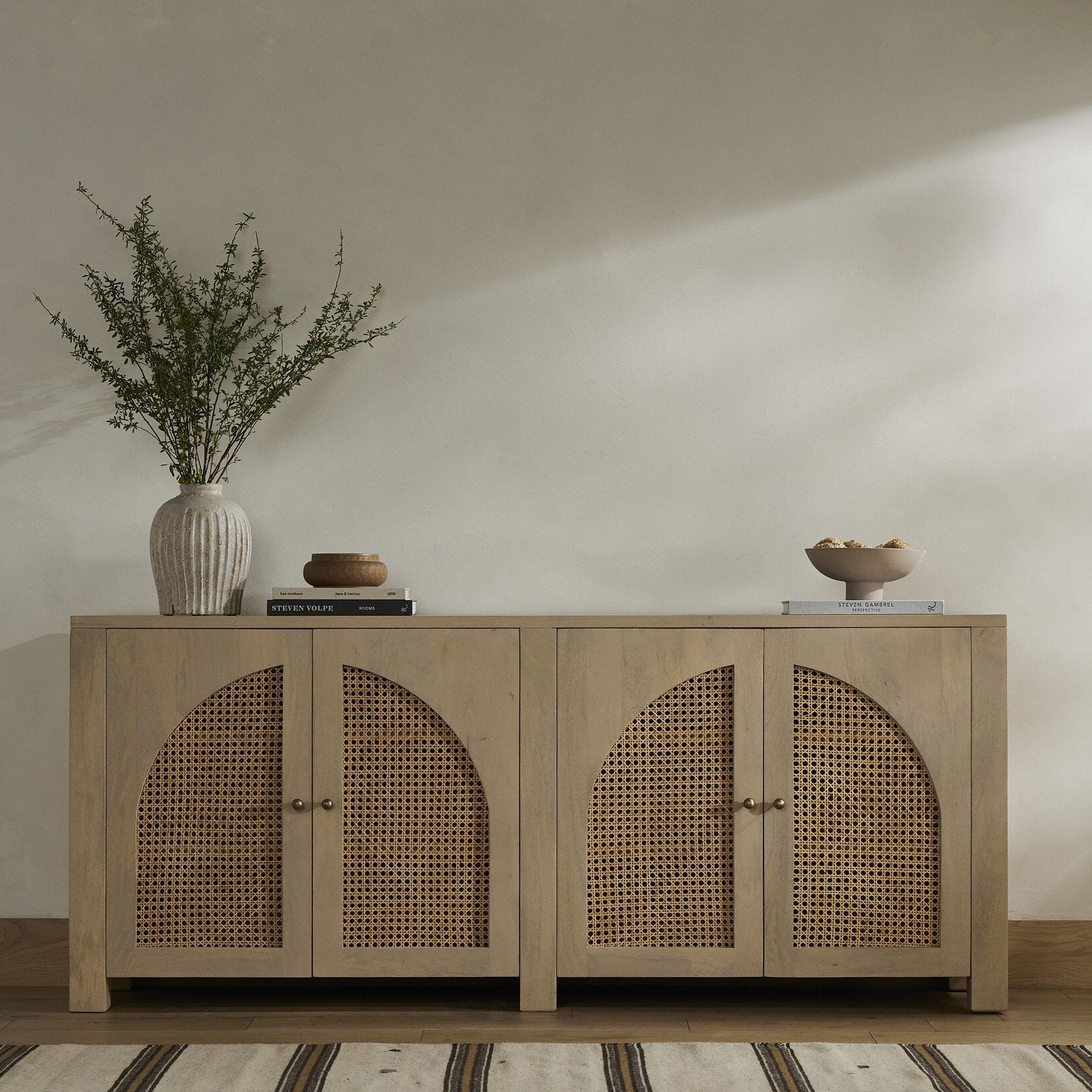 Wooden sideboard with decorative items against a plain wall