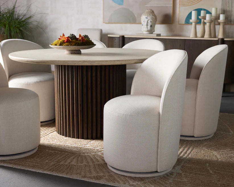 Modern dining room with a round table and white chairs.