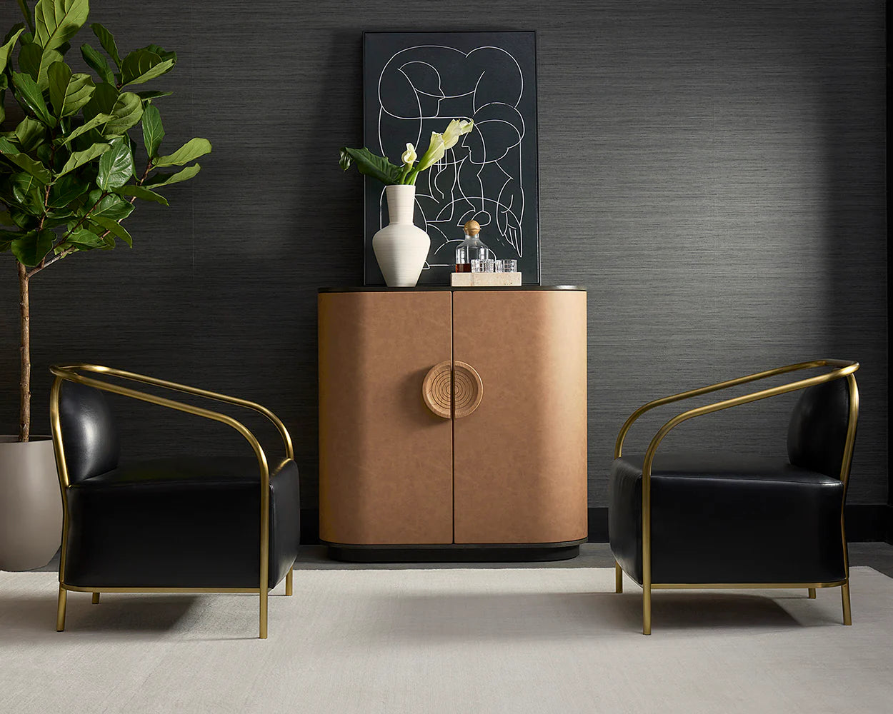 Modern interior with a brown leather cabinet, black  leather chairs with gold armrests, and a plant.