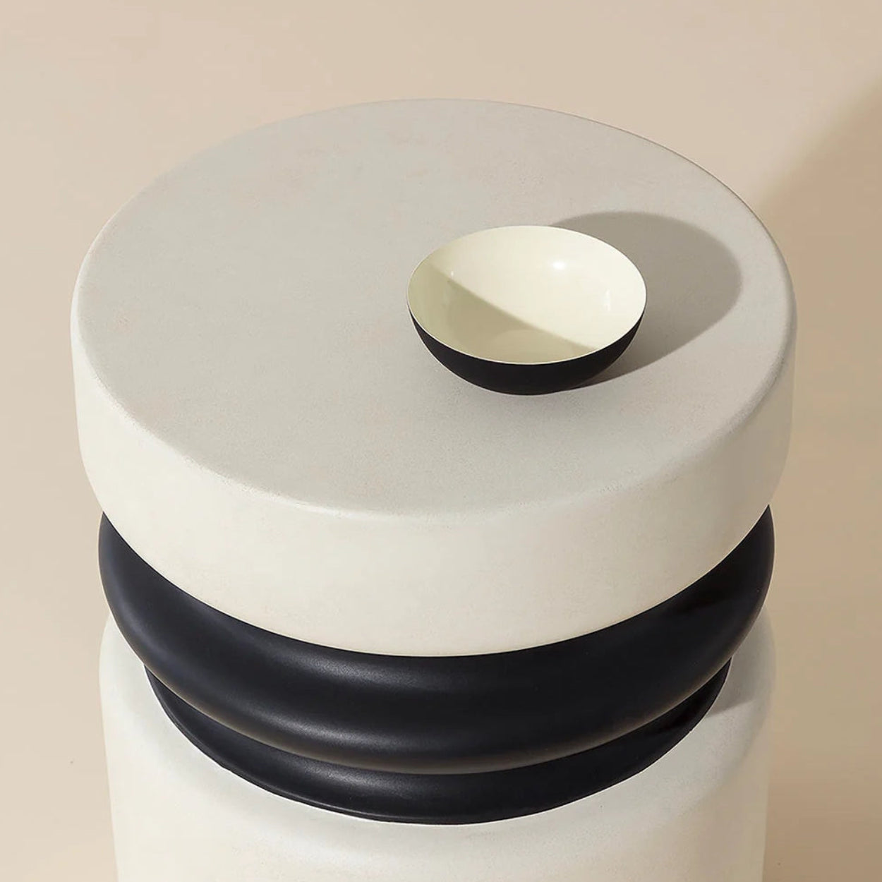 Round end table with black and white design on a beige background