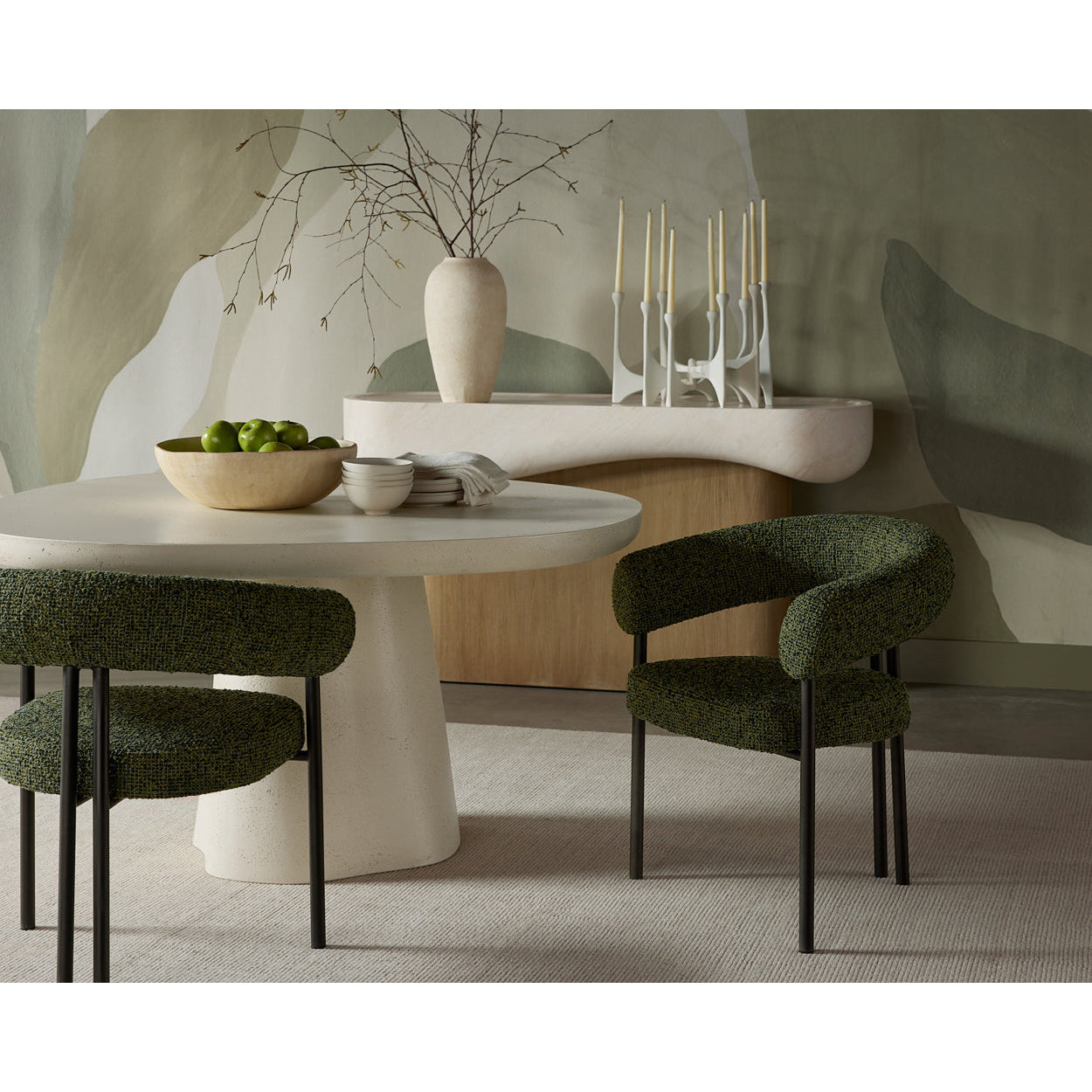 Dining area with a round table and green chairs in a modern interior setting.