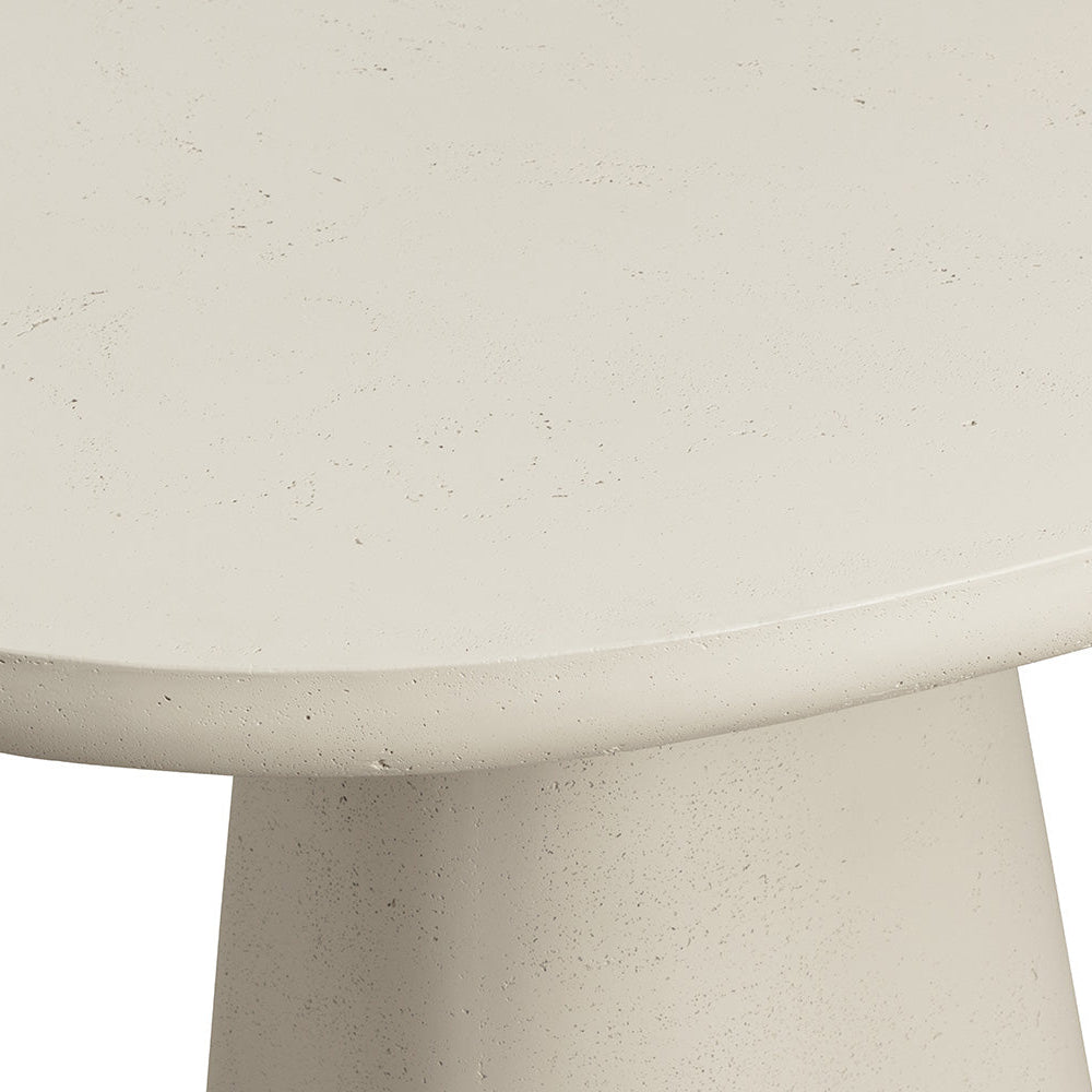 Close-up of a round concrete table with a textured surface.
