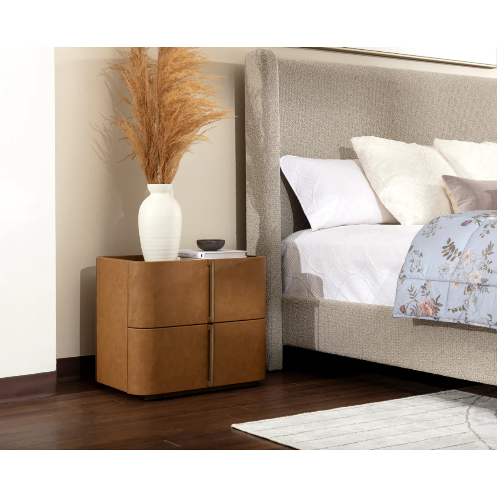 Brown nightstand next to a bed with white bedding and decorative pillows.