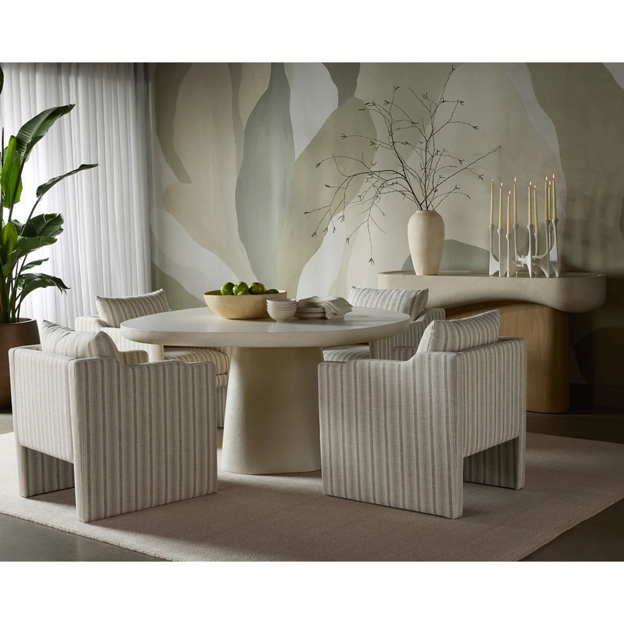 Dining room with a round table and striped chairs in a modern interior setting.