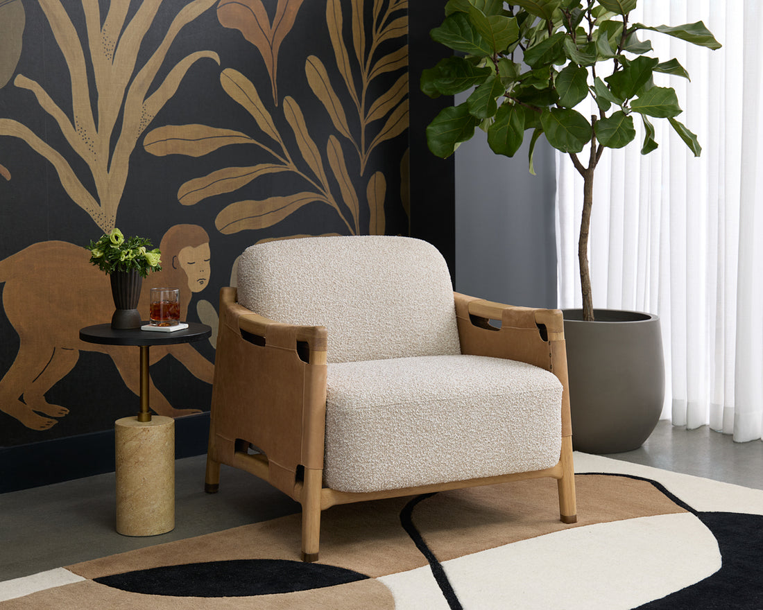 Beige armchair in a room with decorative wall, plant, and small table.