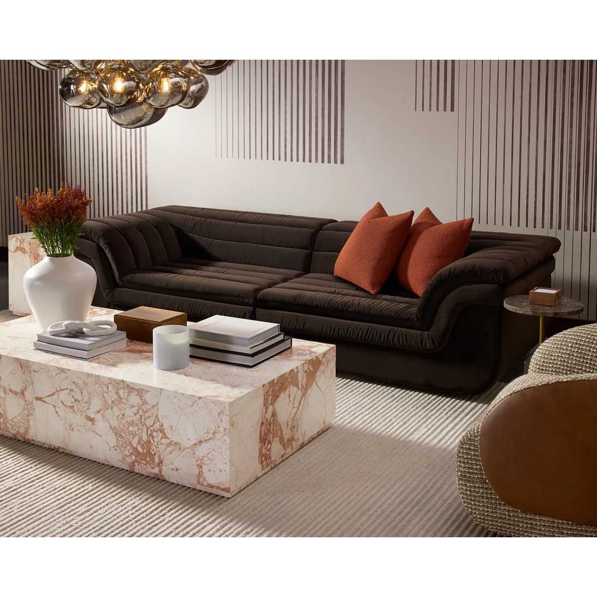 Modern living room with a brown sectional sofa, marble coffee table, and decorative items.