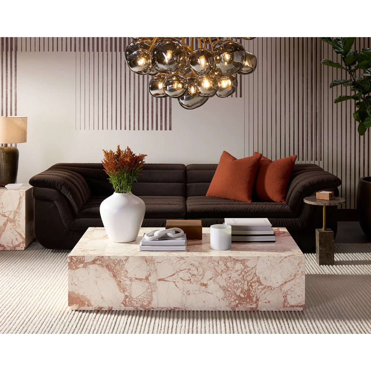 Modern living room with a brown sofa, marble coffee table, and decorative elements.