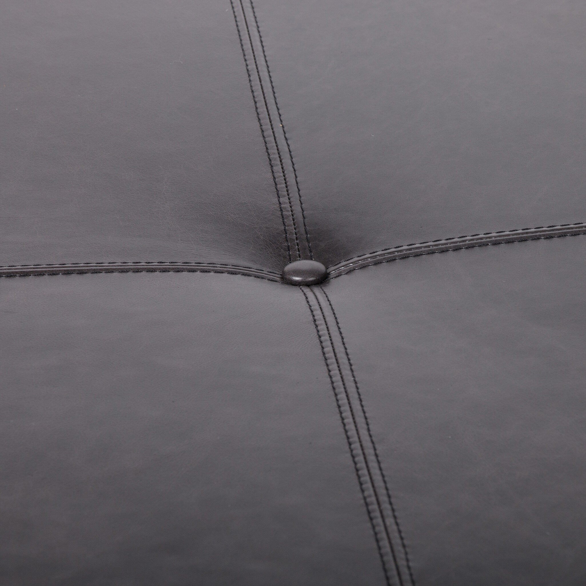Close-up of a black leather ottoman with stitching details
