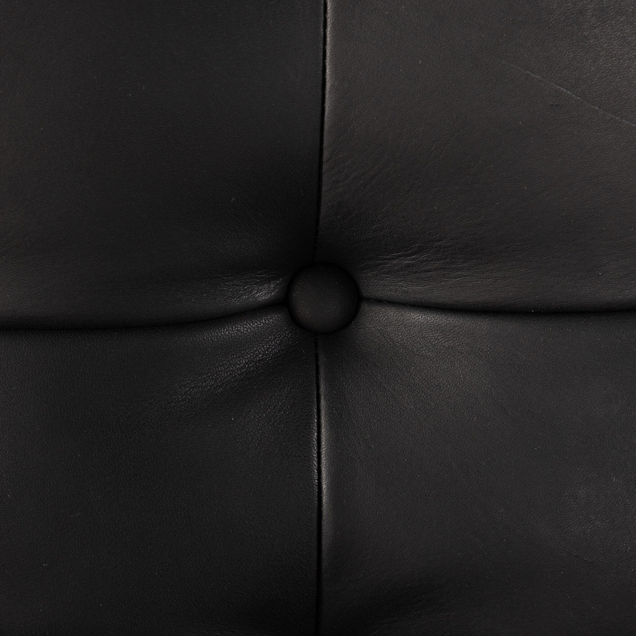 Close-up of black leather upholstery with stitching detail