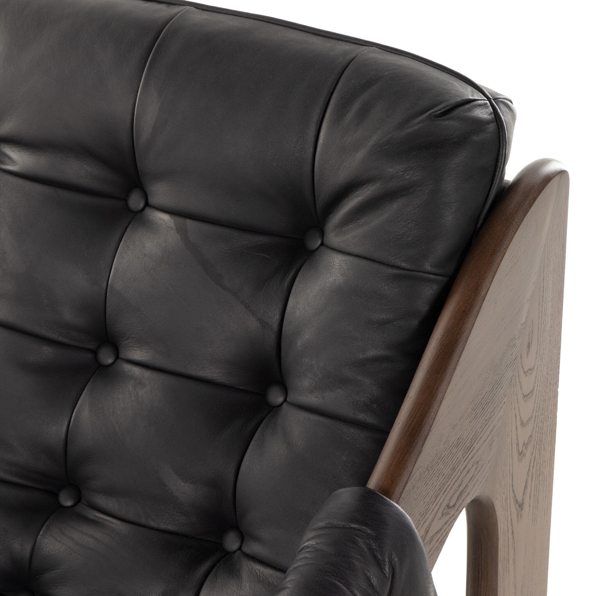 Close-up of a black leather chair with wooden armrests on a white background