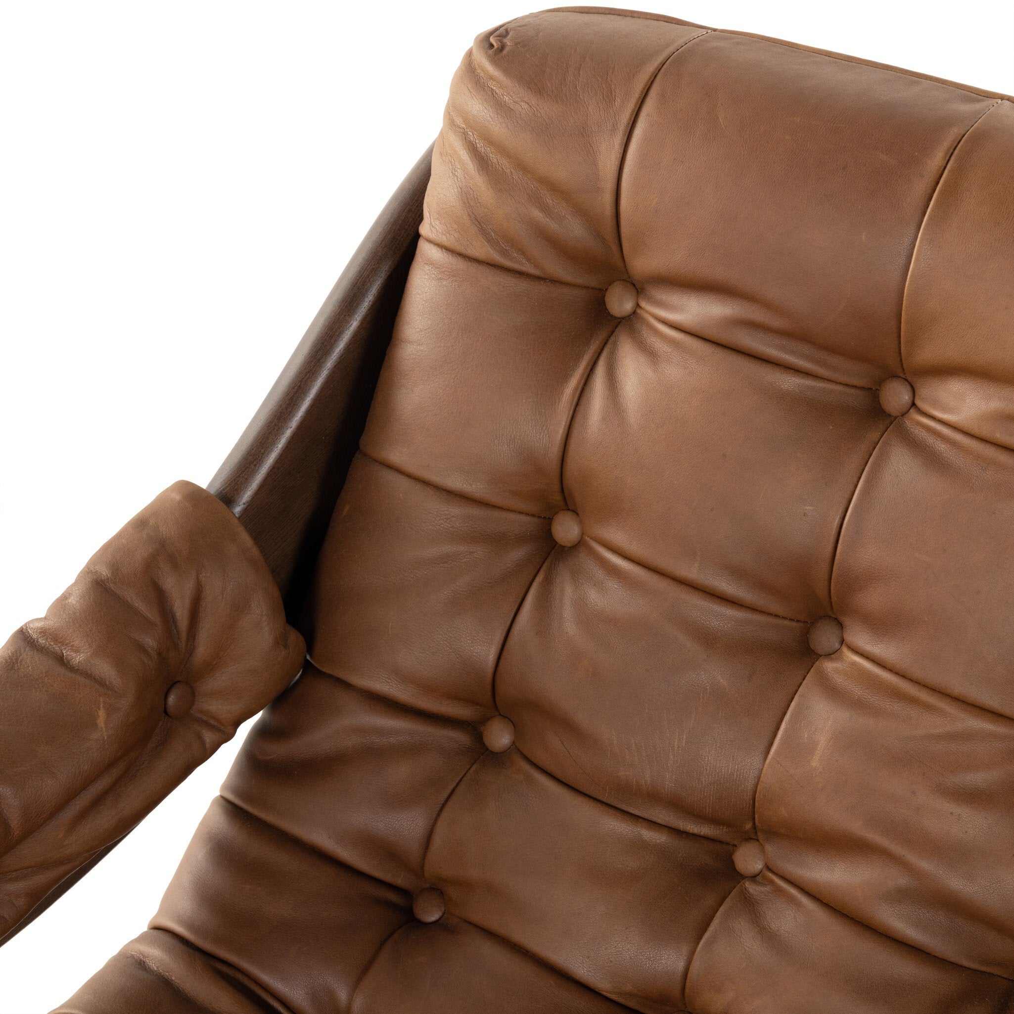 Close-up of a brown leather chair with tufted backrest on a white background