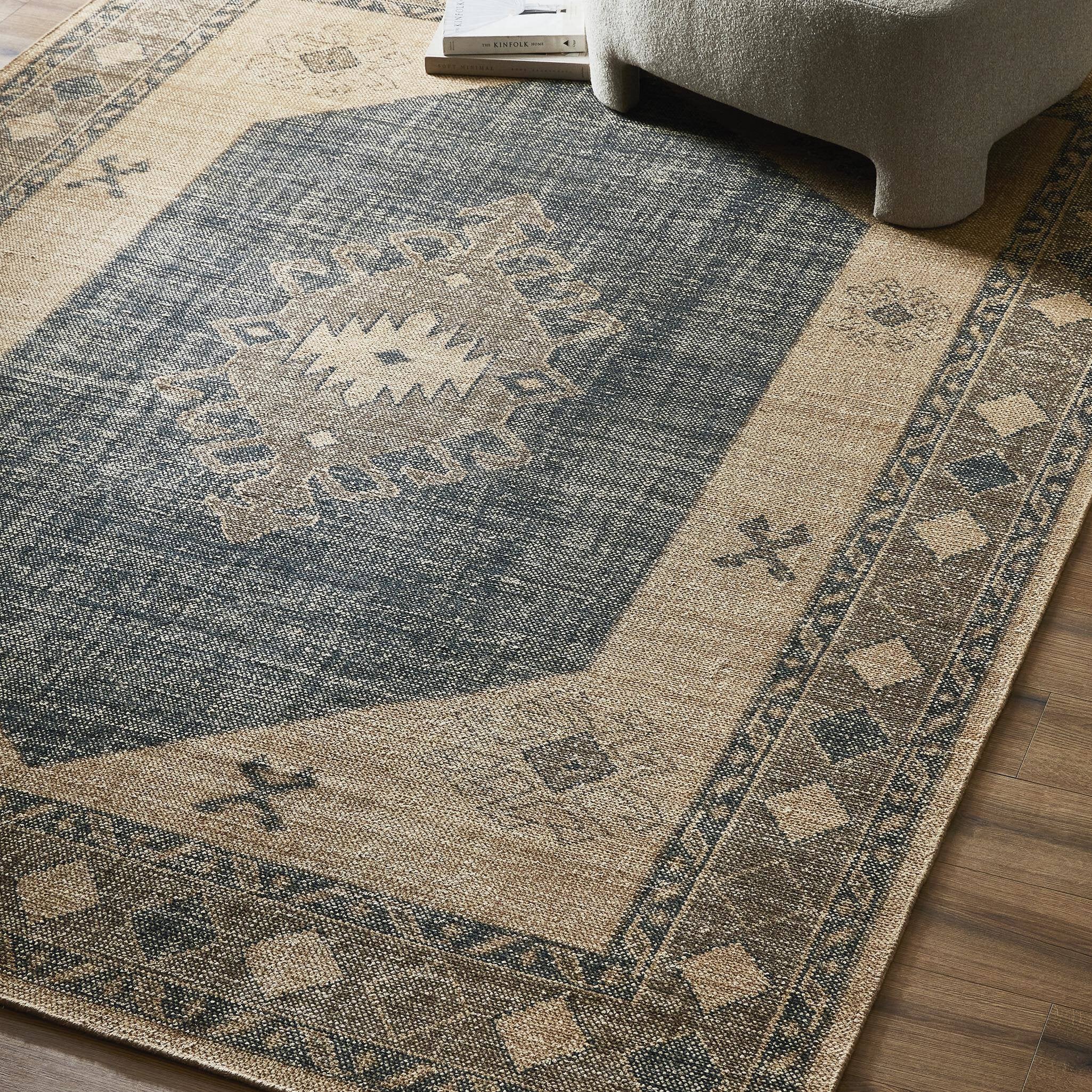 Patterned area rug on a wooden floor with a chair partially visible.