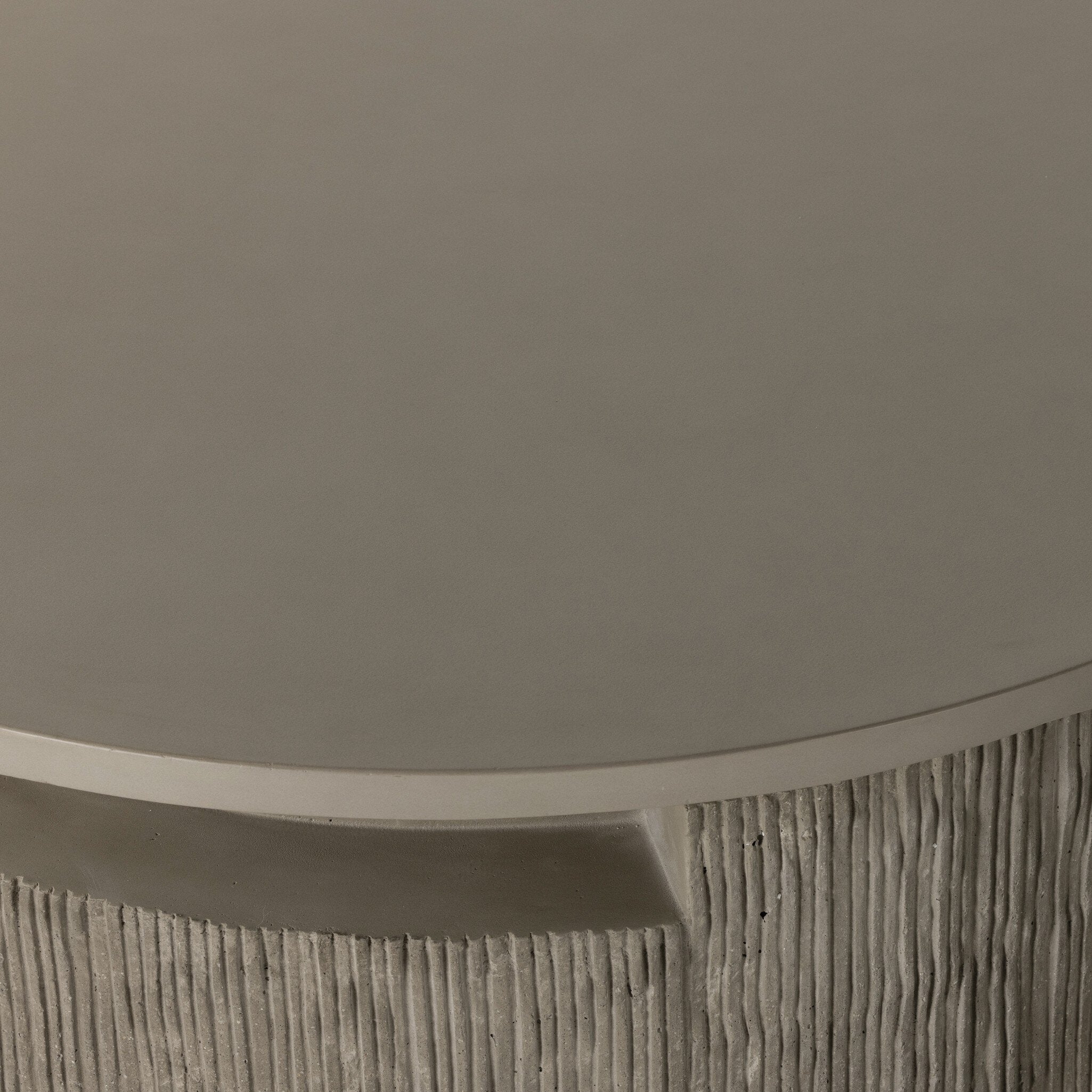 Round outdoor coffee table with textured base and smooth top