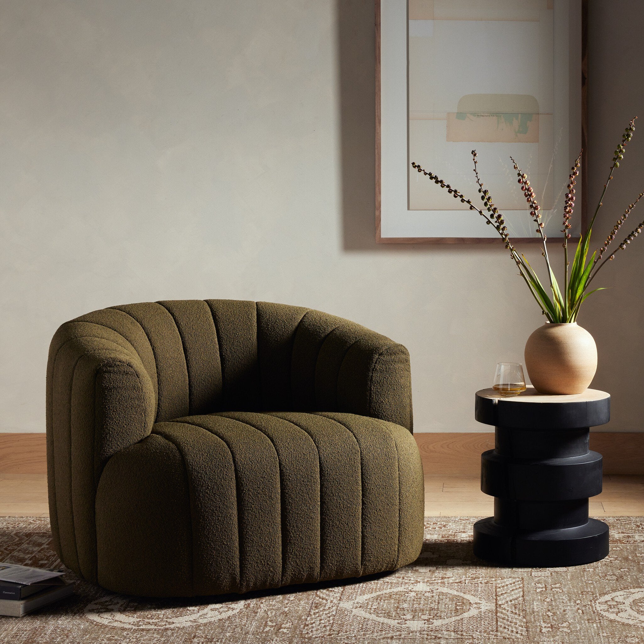 Green armchair in a living room with a side table and decorative elements.