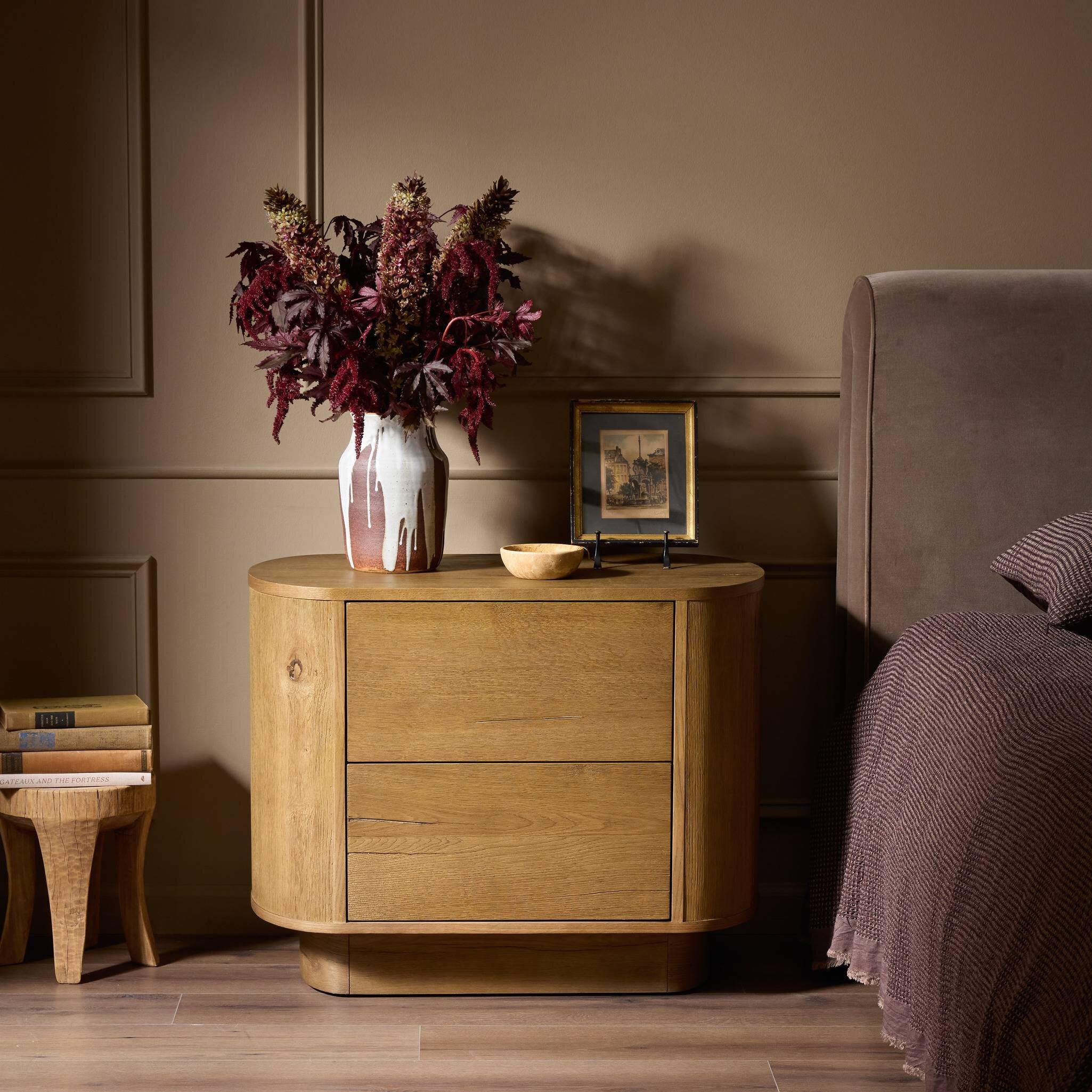 Wooden nightstand with decorative items in a bedroom setting