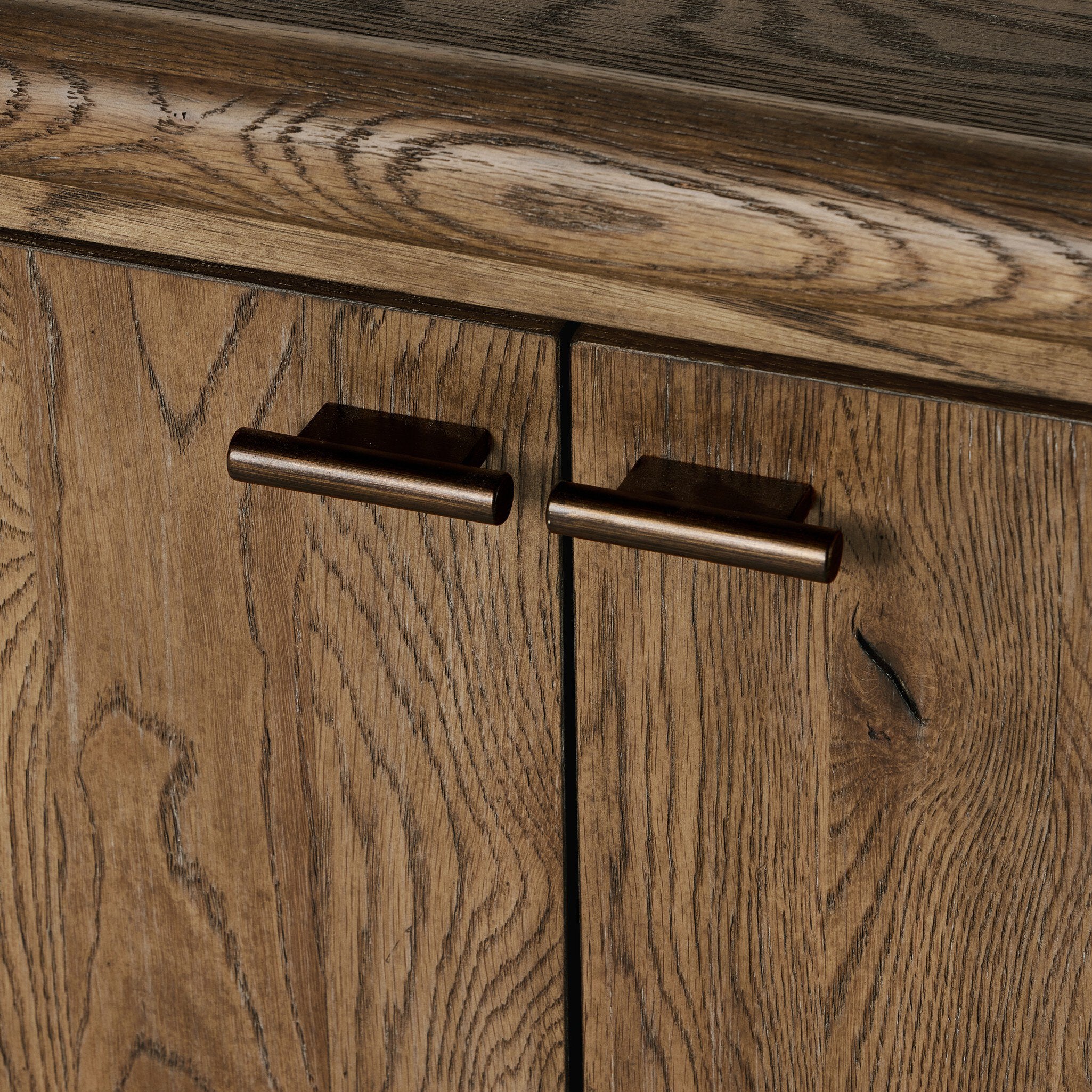 Close-up of wooden cabinet doors with bronze handles