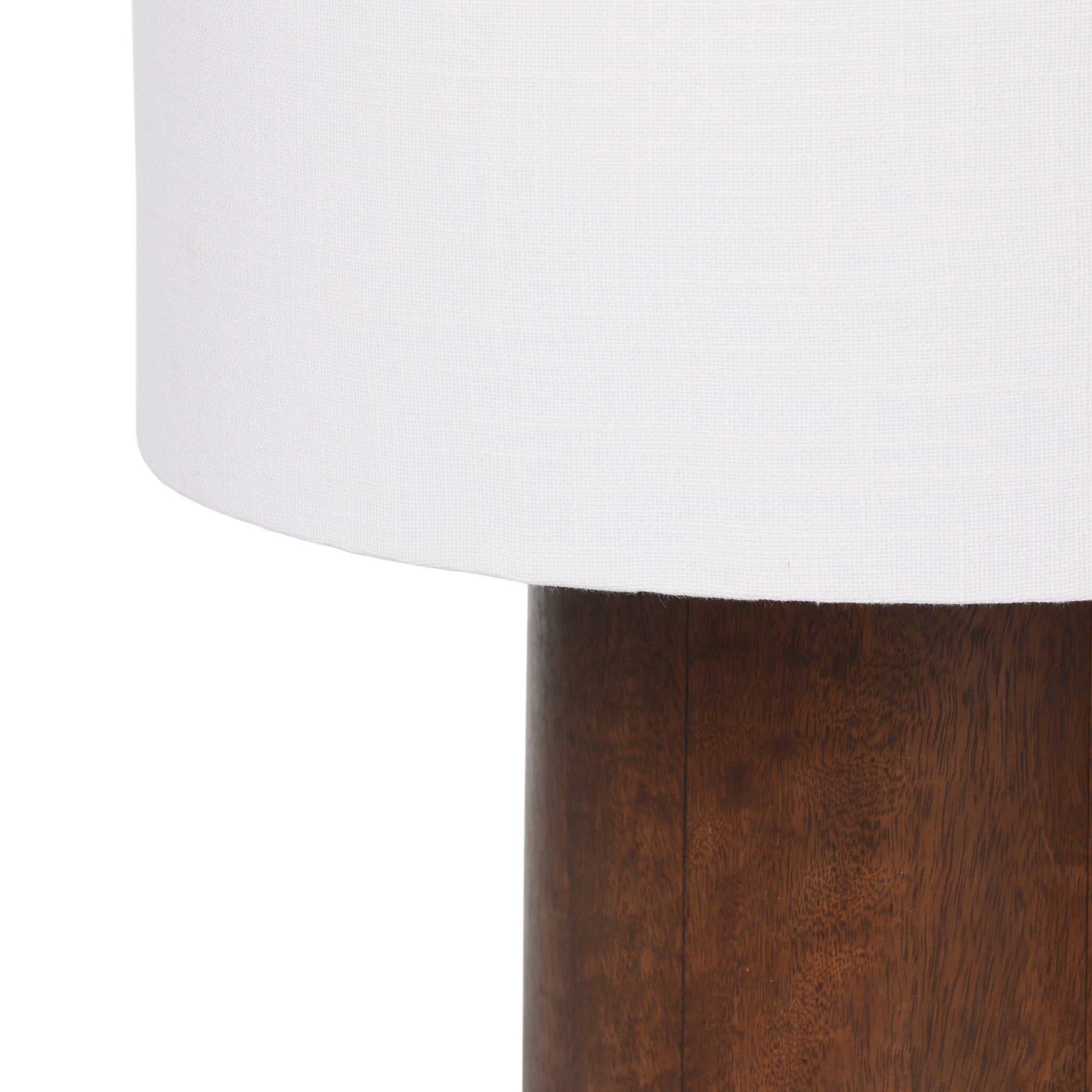 Close-up of a wood table lamp with a white lampshade on a white background