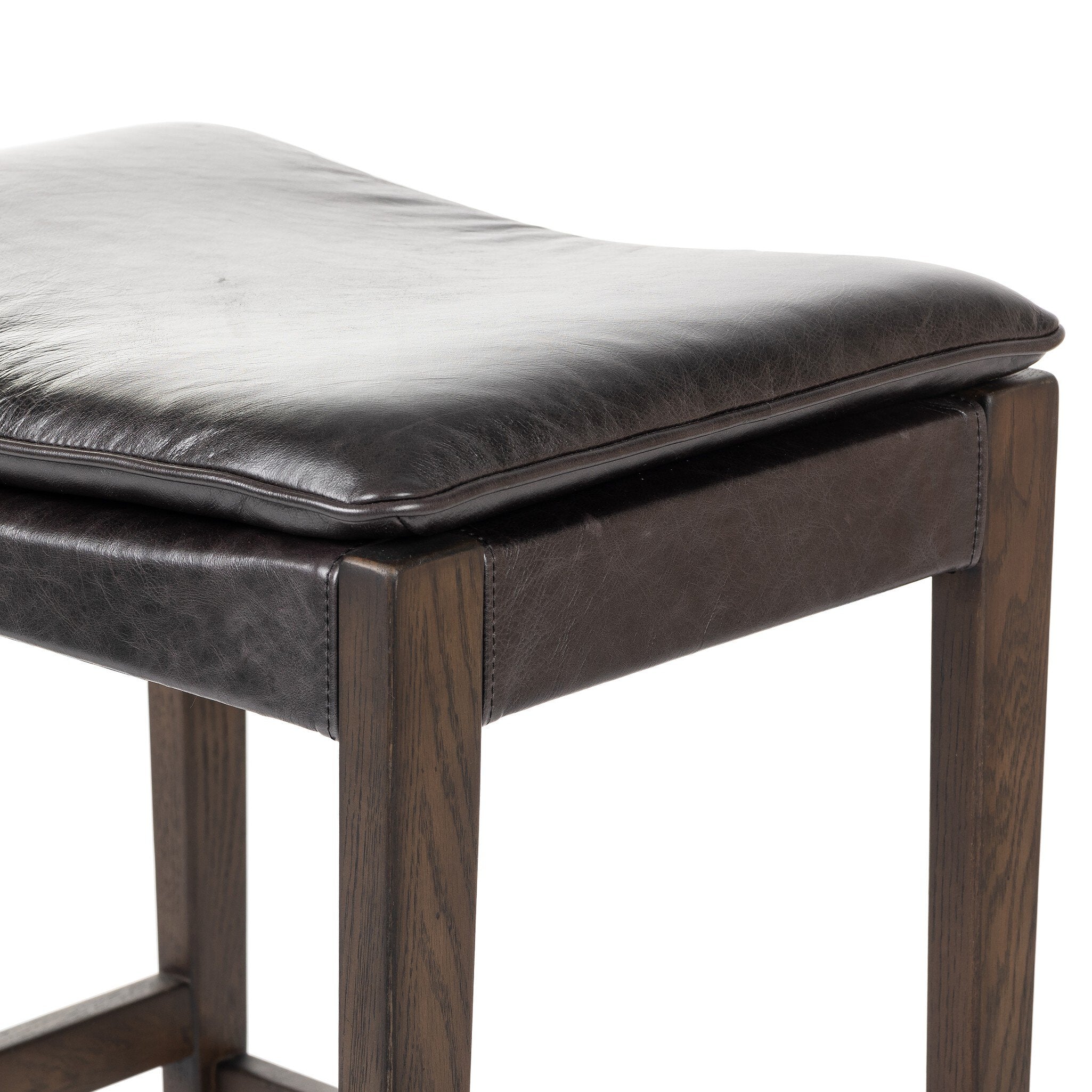 Brown leather stool with wooden legs on a white background