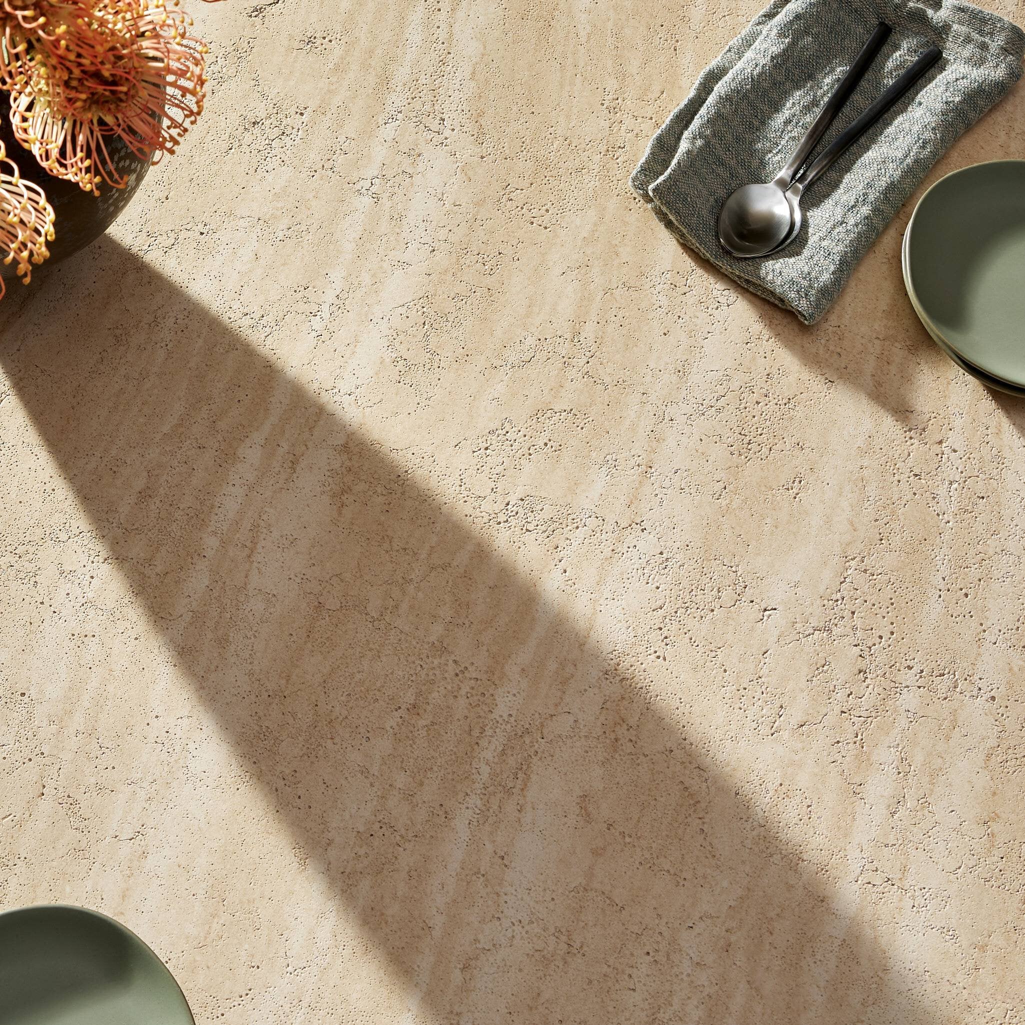Beige concrete surface with green plates and a towel.