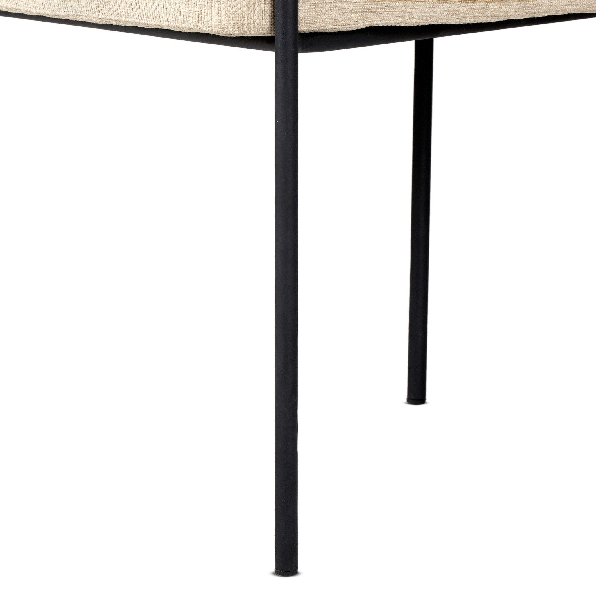 Close-up of a black metal table leg with a beige cushioned surface on a white background