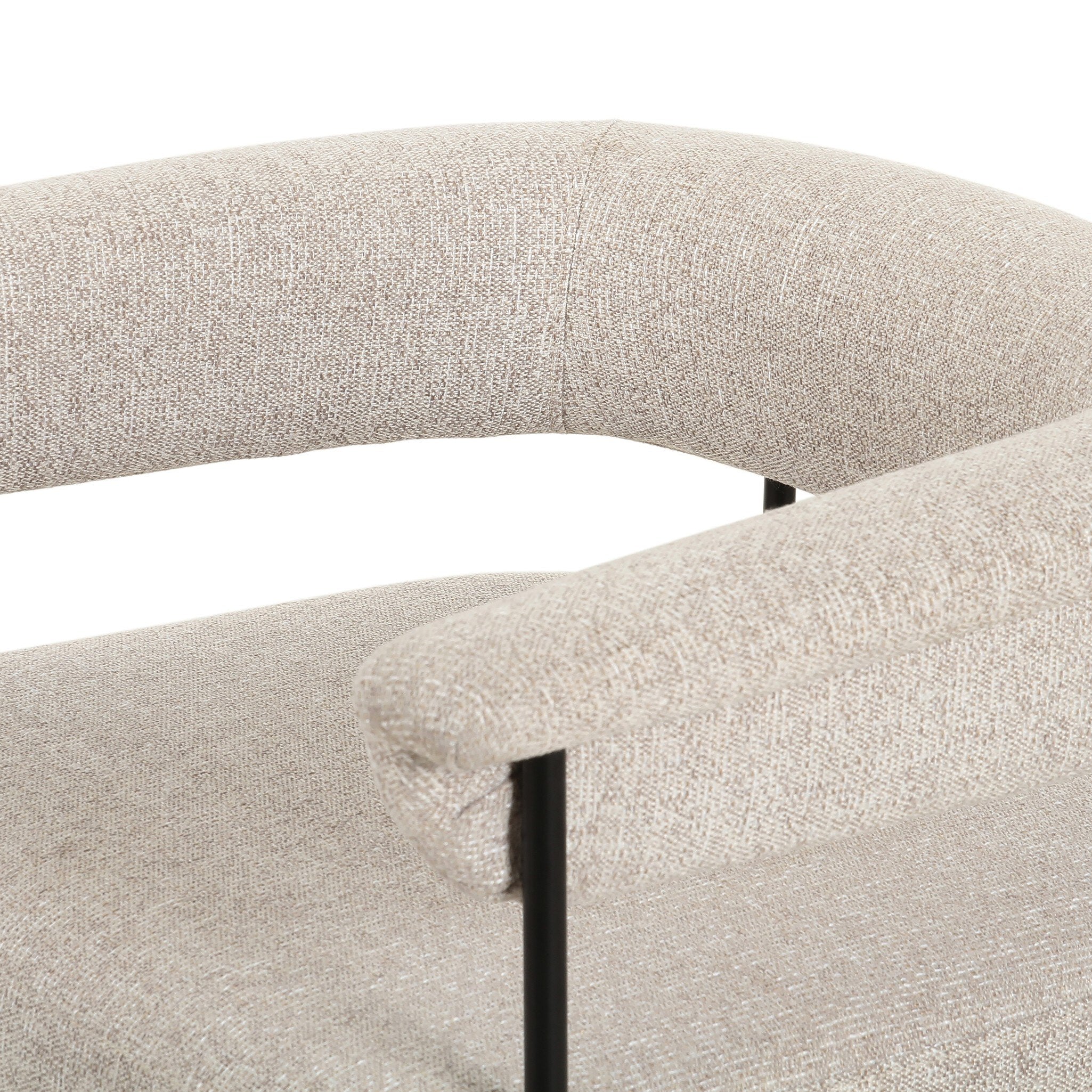 Close-up of a textured beige chair with a black metal frame.
