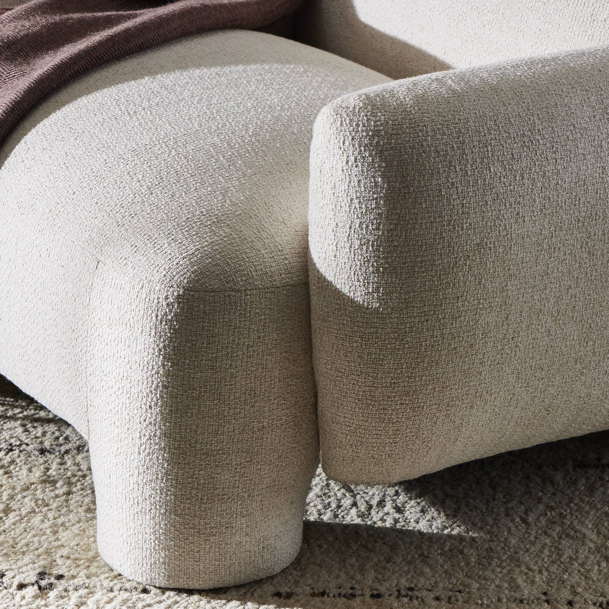 Close-up of a textured beige sofa on a carpeted floor