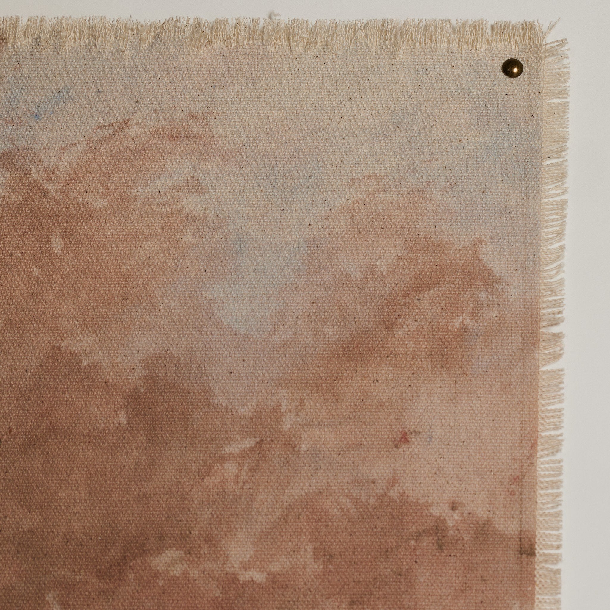 Textured fabric with a brown stain on a beige background