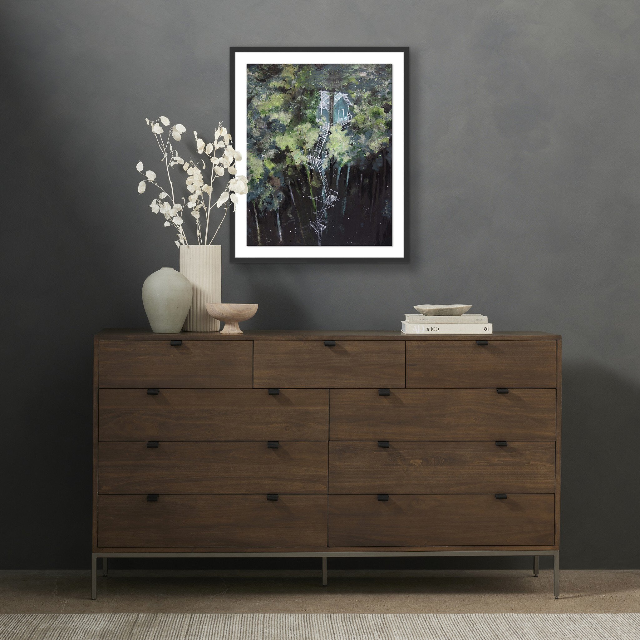 Wooden dresser with decorative items against a dark wall