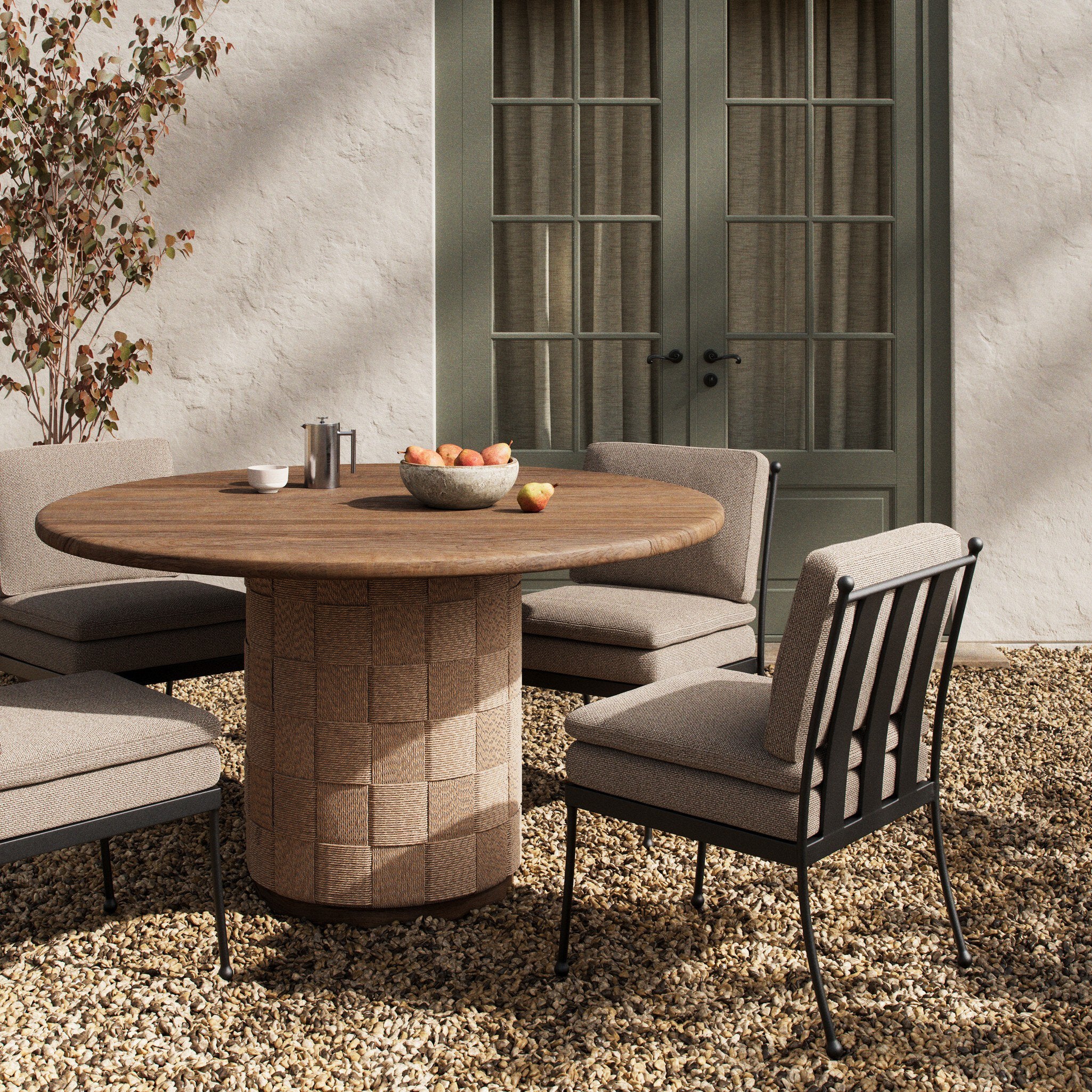 Outdoor dining area with wooden table and chairs on a stone patio.
