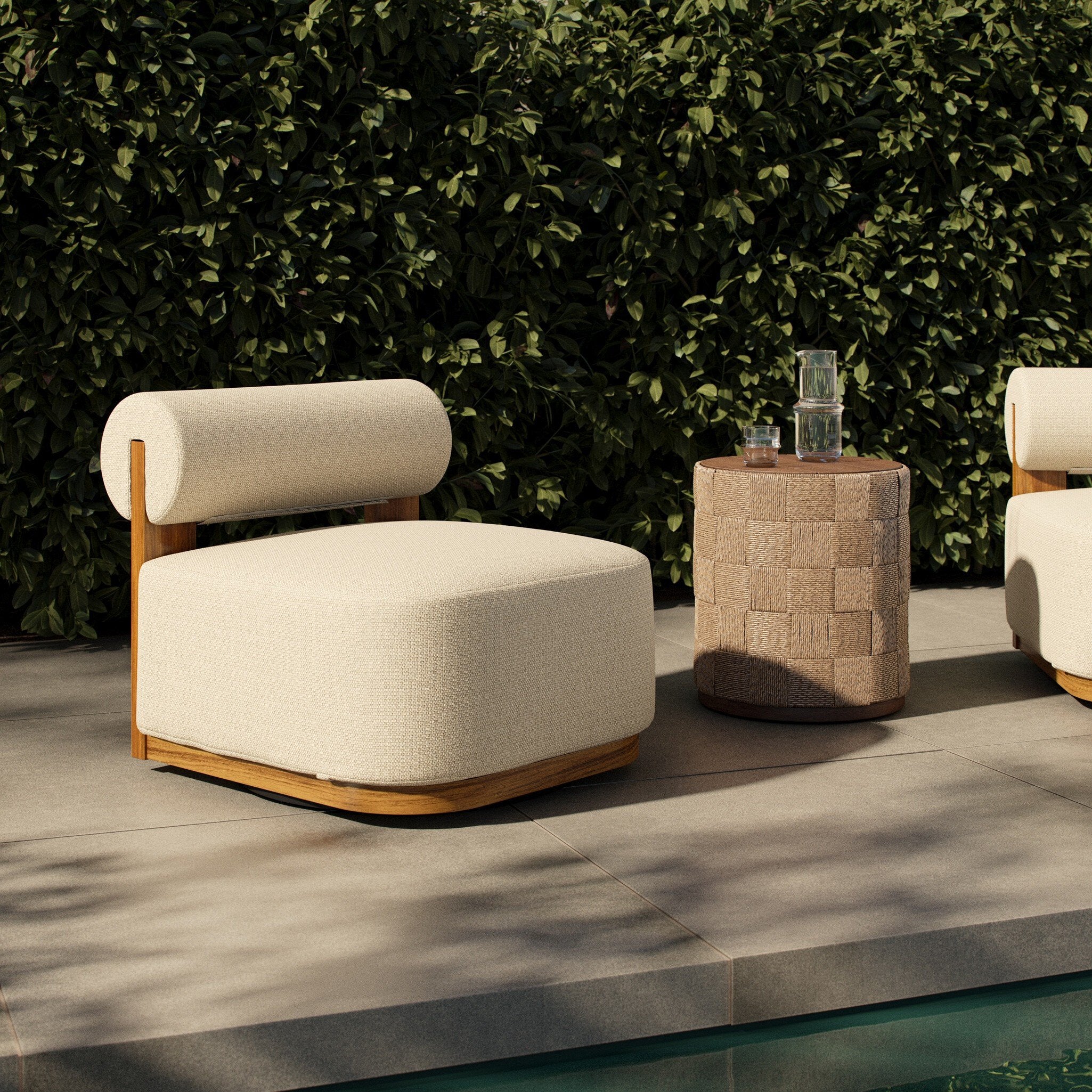Modern outdoor chair with wooden frame and beige cushion next to a small table with a woven top on a patio.