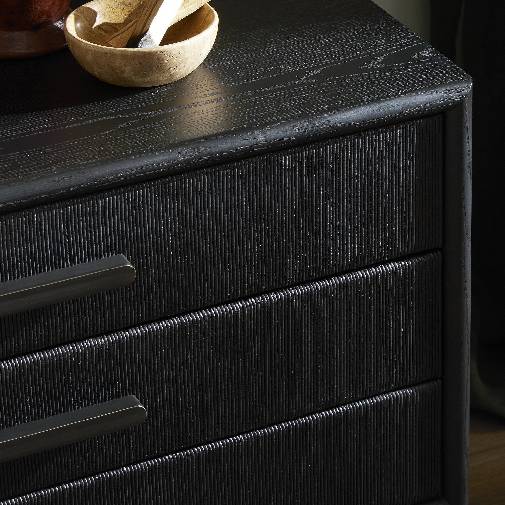 Dark wooden dresser with three drawers and a small bowl on top.