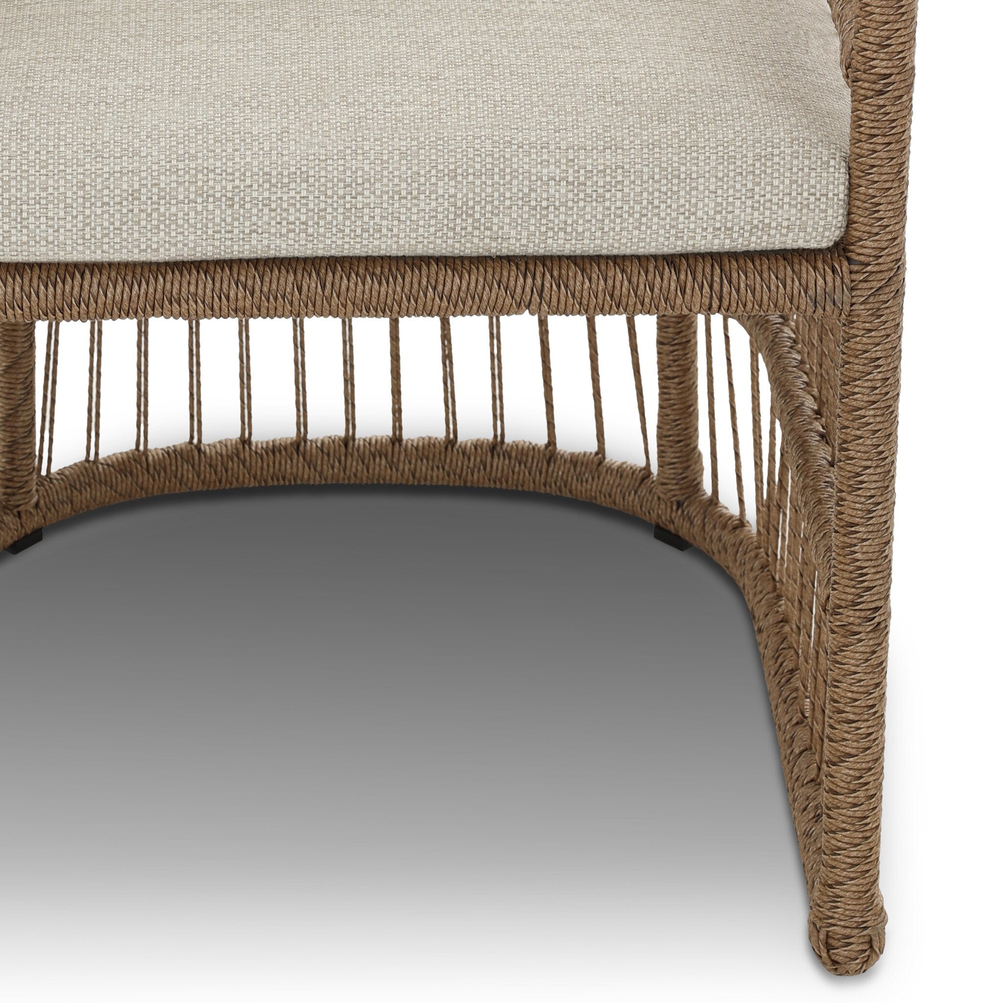 Close-up of a wicker chair with a beige cushion on a white background