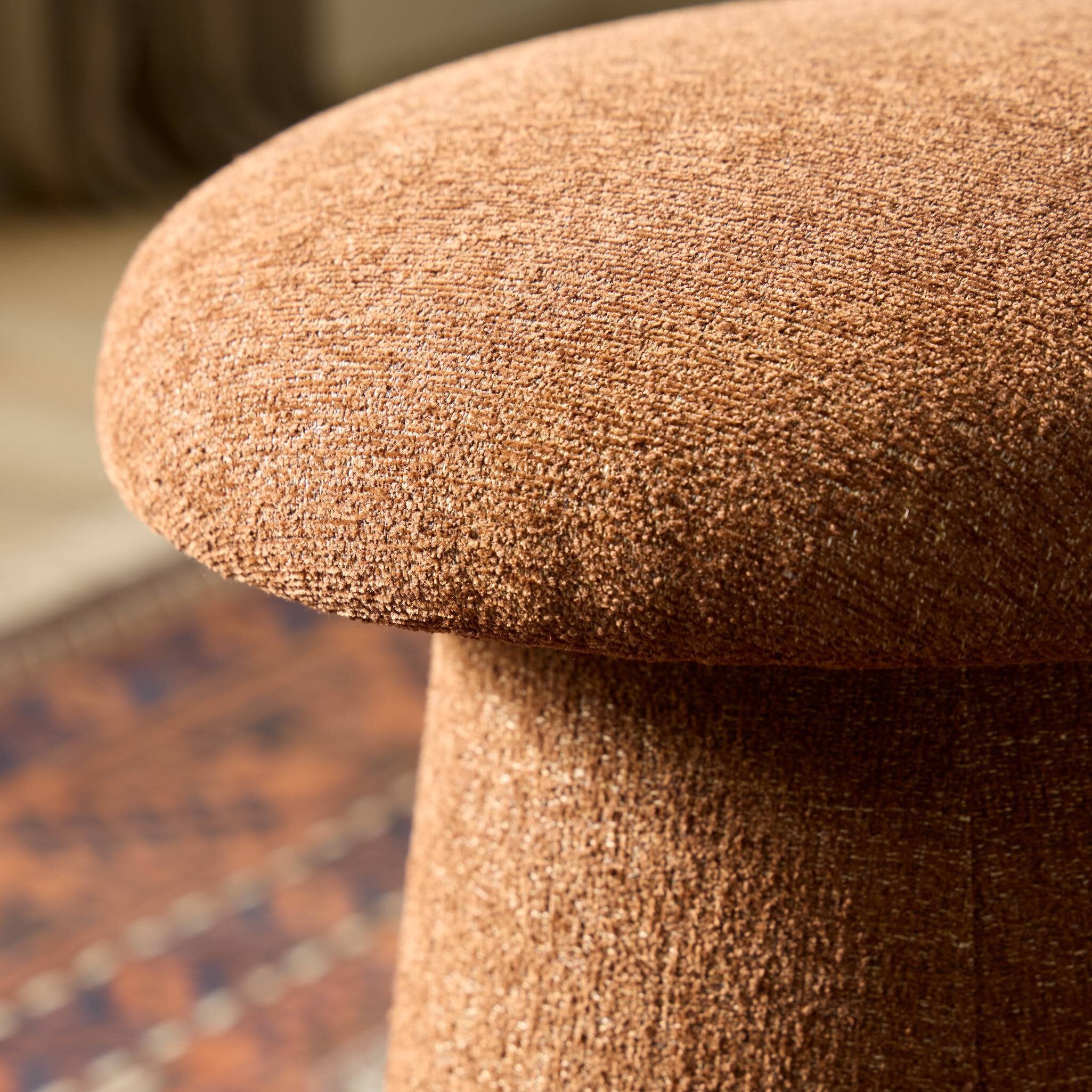 Close-up of a textured brown stool with a blurred background