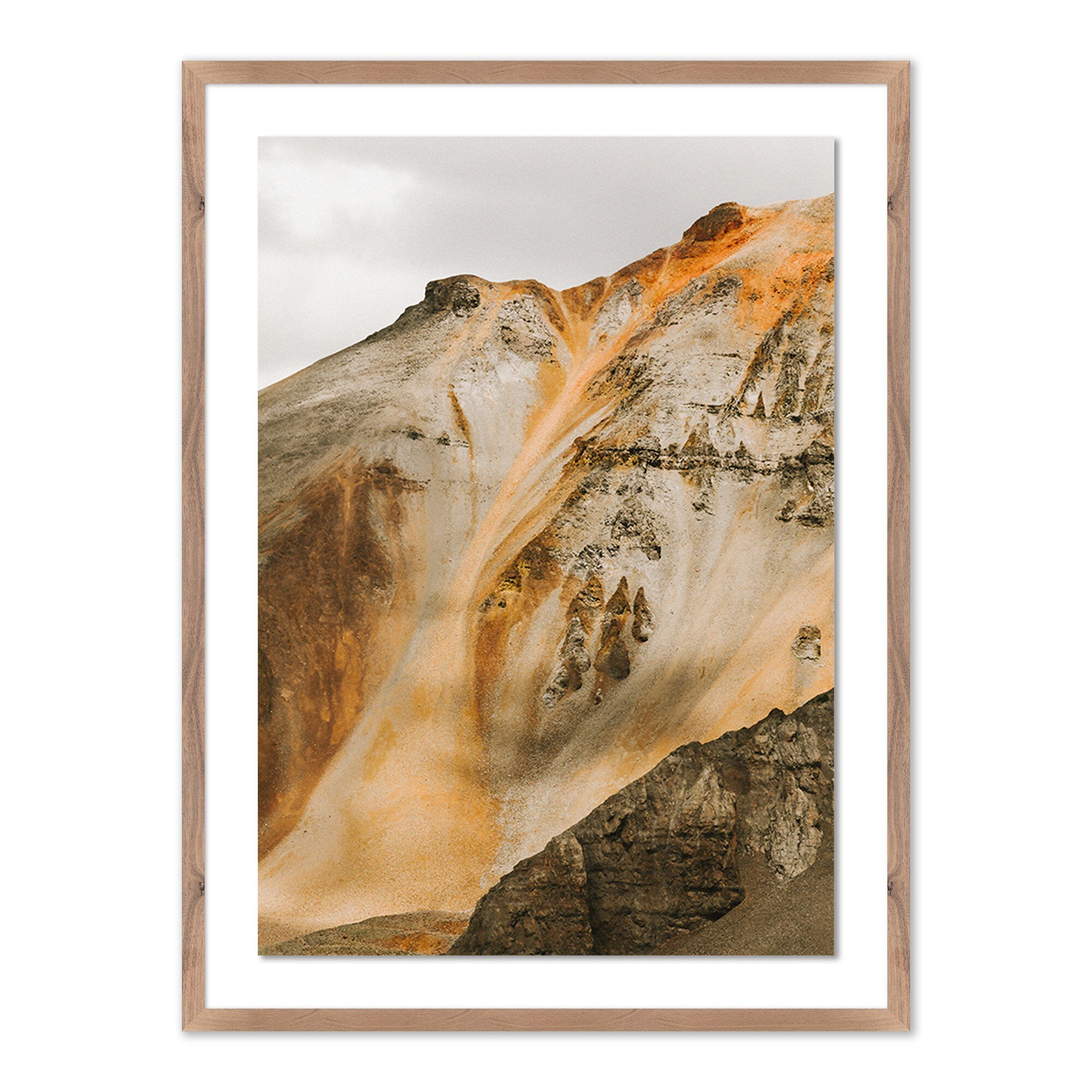 Framed artwork of a mountain landscape with warm colors.